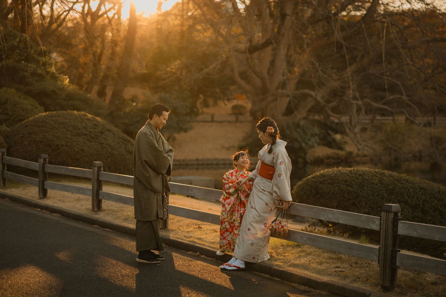 Couple in traditional Japanese attire during sunset in a garden setting.