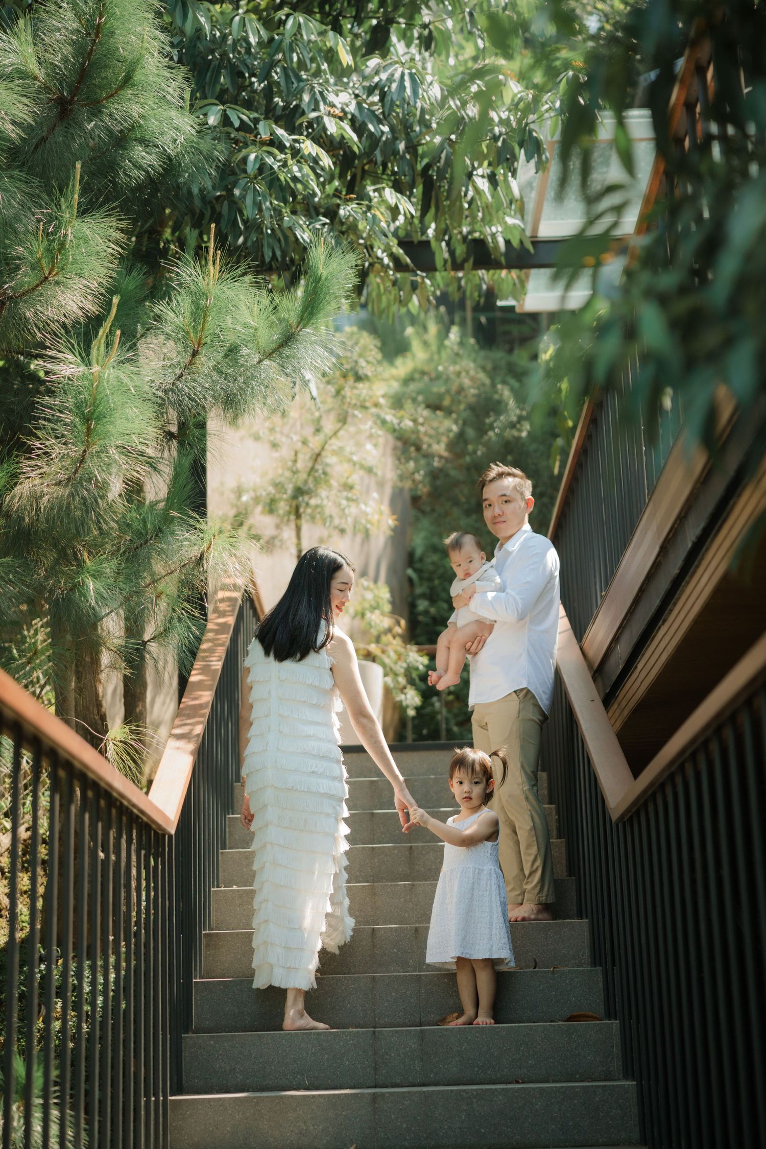 Family walking up outdoor staircase surrounded by greenery.
