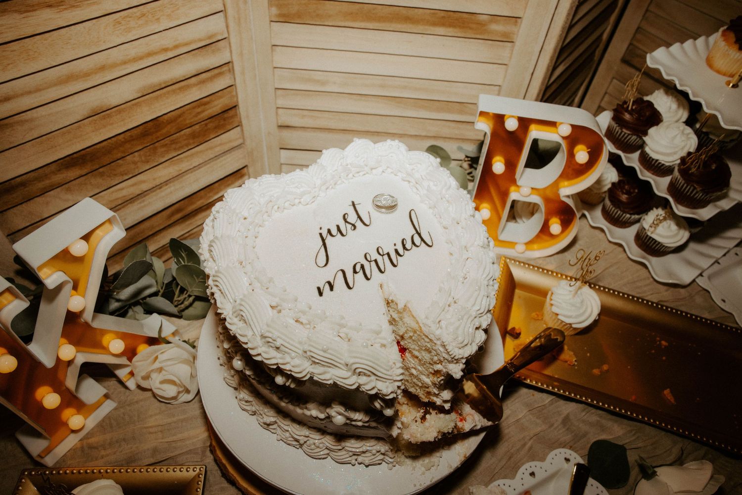 Elegant white heart-shaped wedding cake decorated with just married topper.