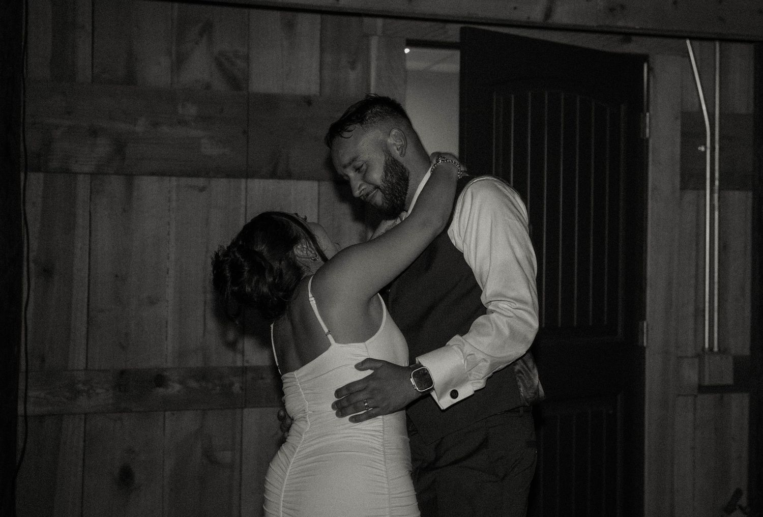 Bride and groom sharing intimate first dance in black and white wedding photo.