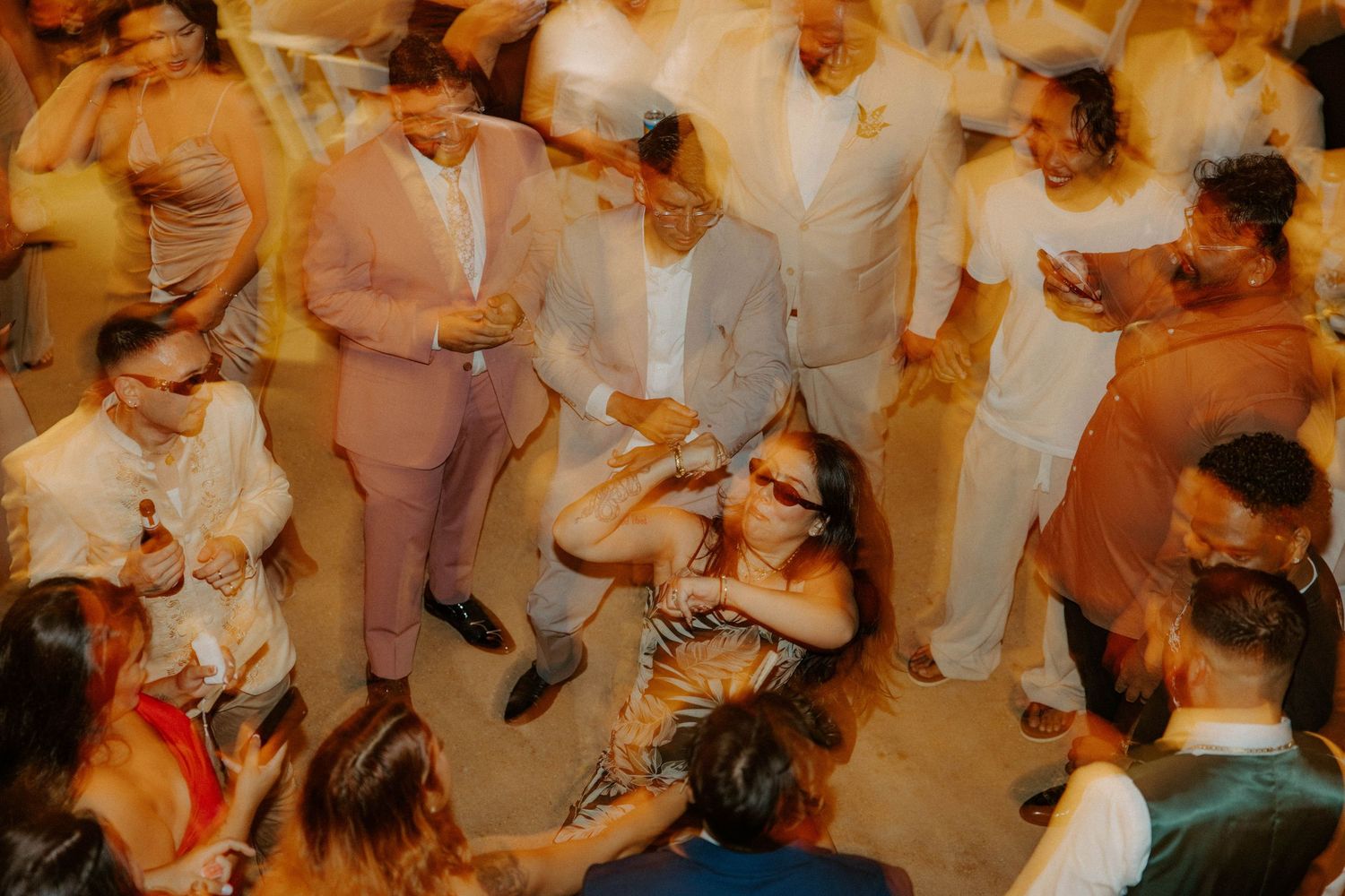 Overhead view of wedding guests dancing and celebrating on the dance floor at reception.
