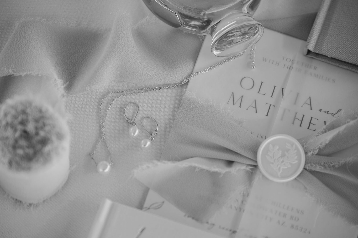 Black and white detail shot of wedding stationery with wax seals and delicate styling.