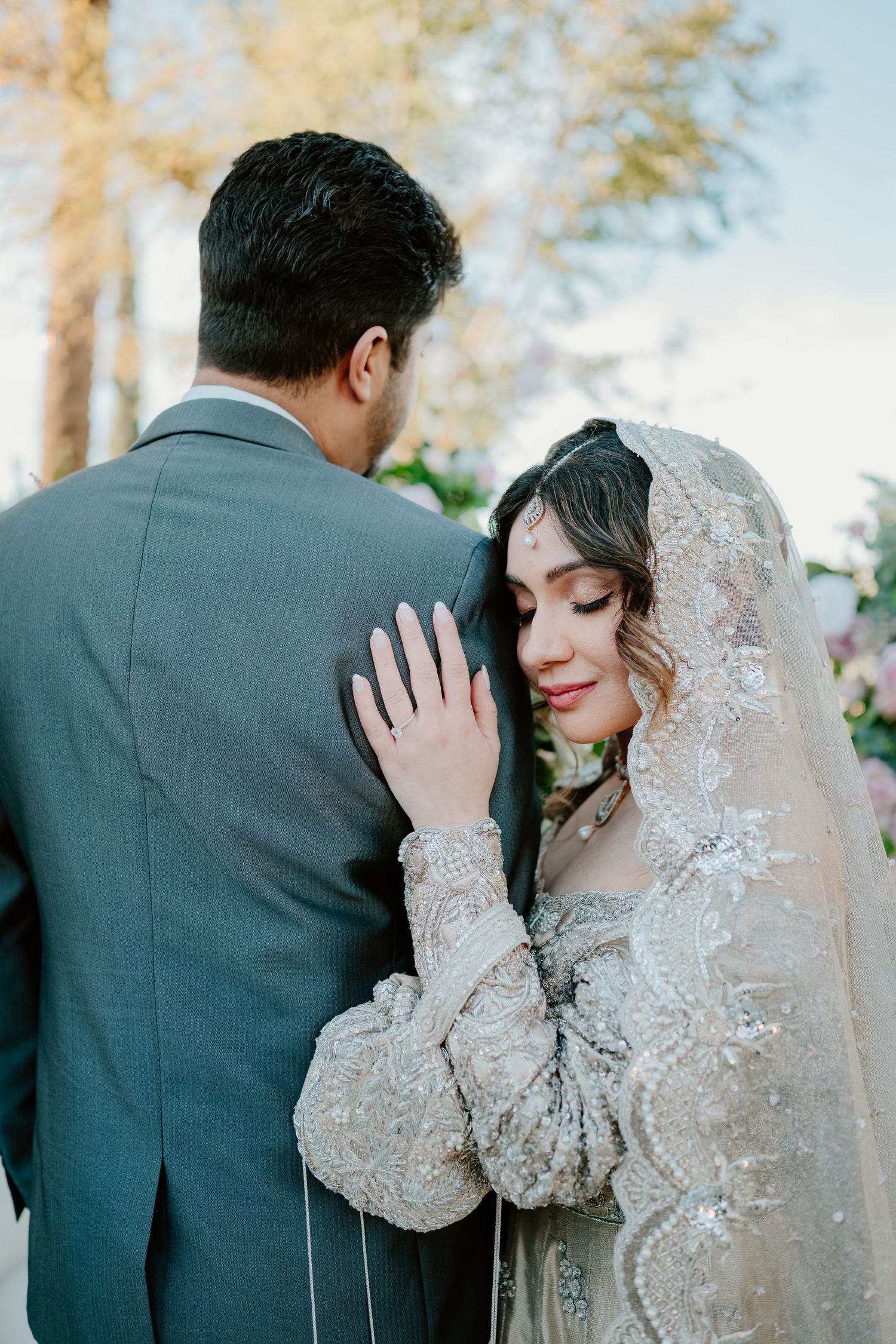 A tender wedding portrait showing an intimate moment between newlyweds, featuring delicate lace veil details.