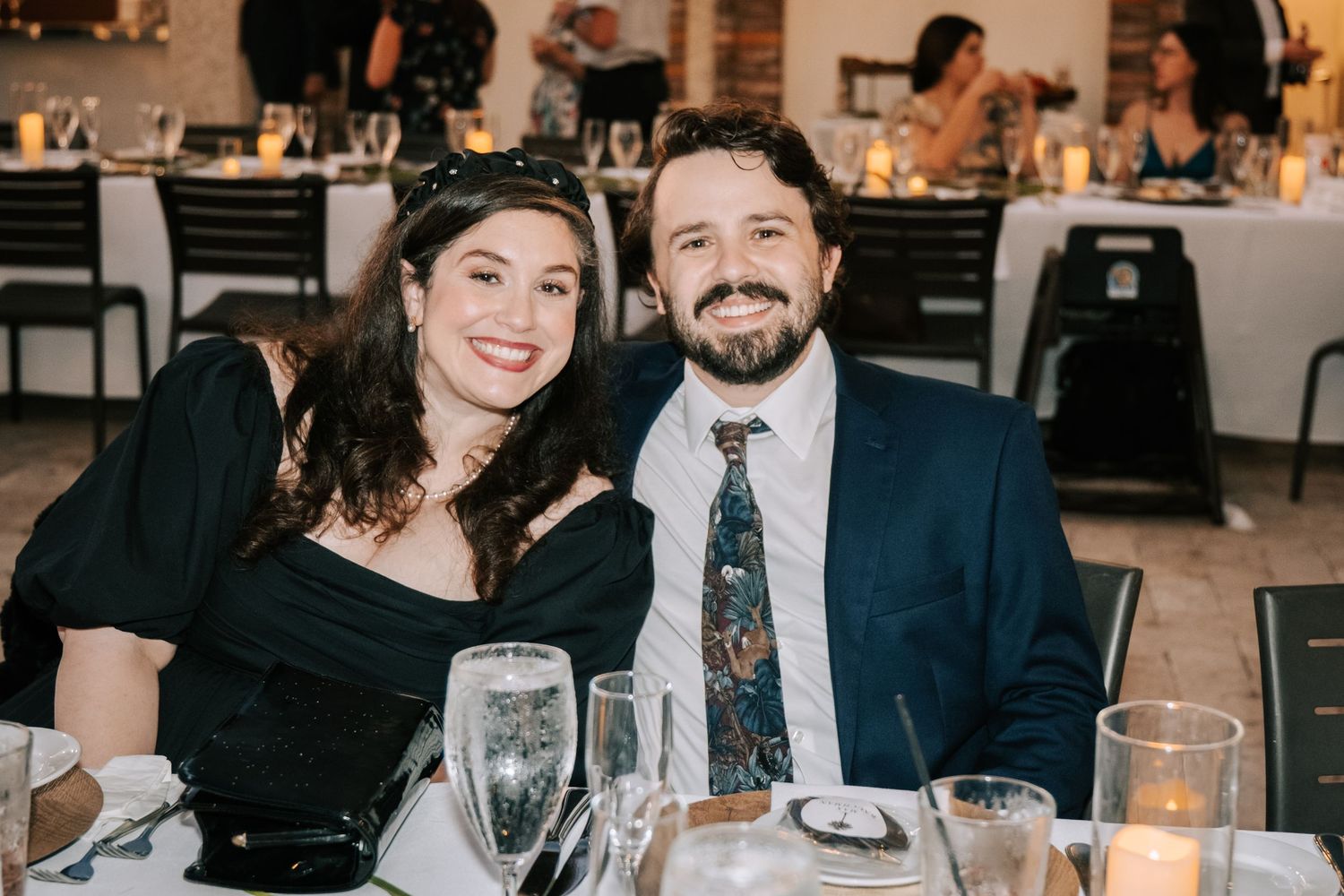 An intimate wedding reception dinner setting with candlelight and formal place settings.