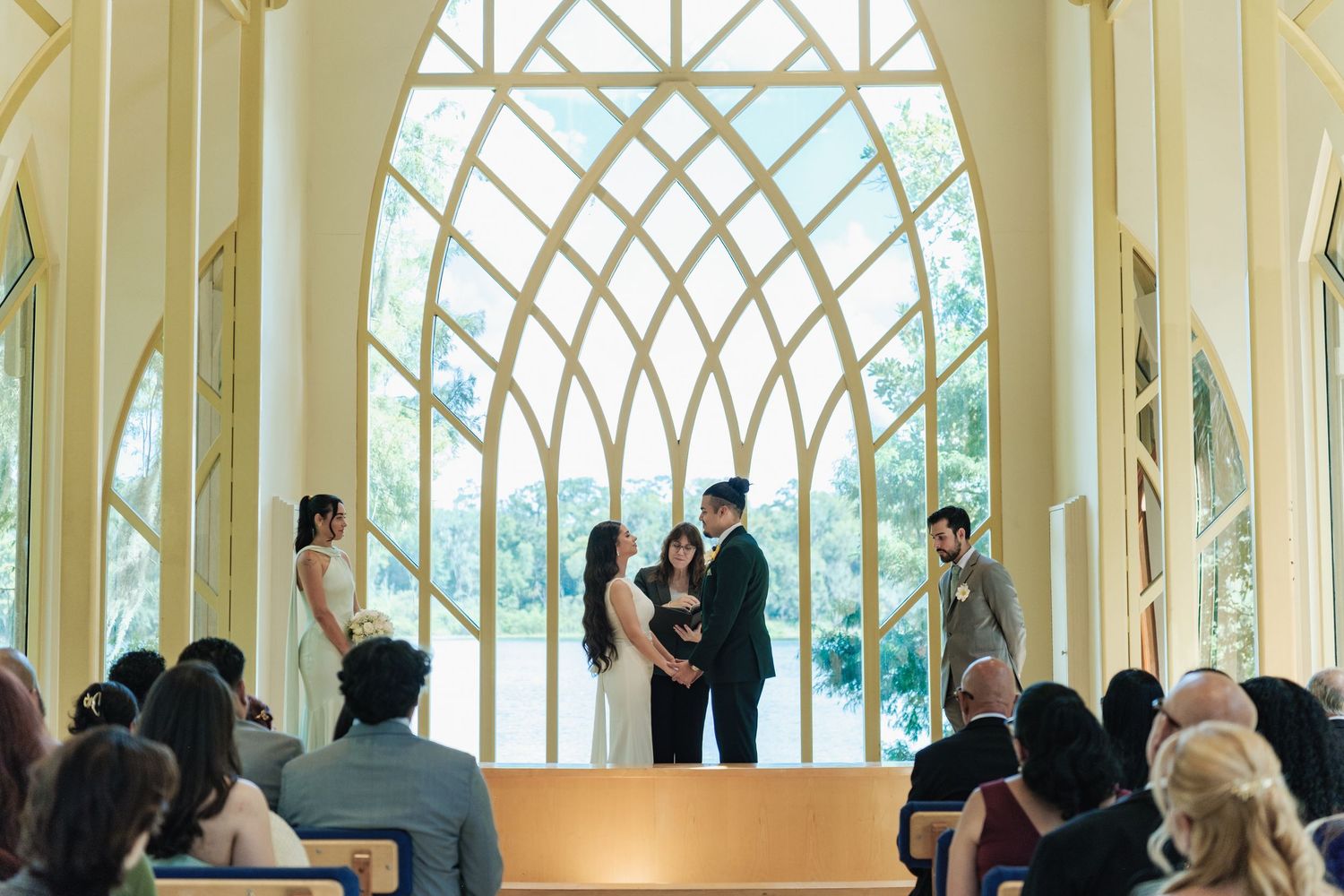Elegant wedding ceremony venue with arched windows and natural light streaming in.