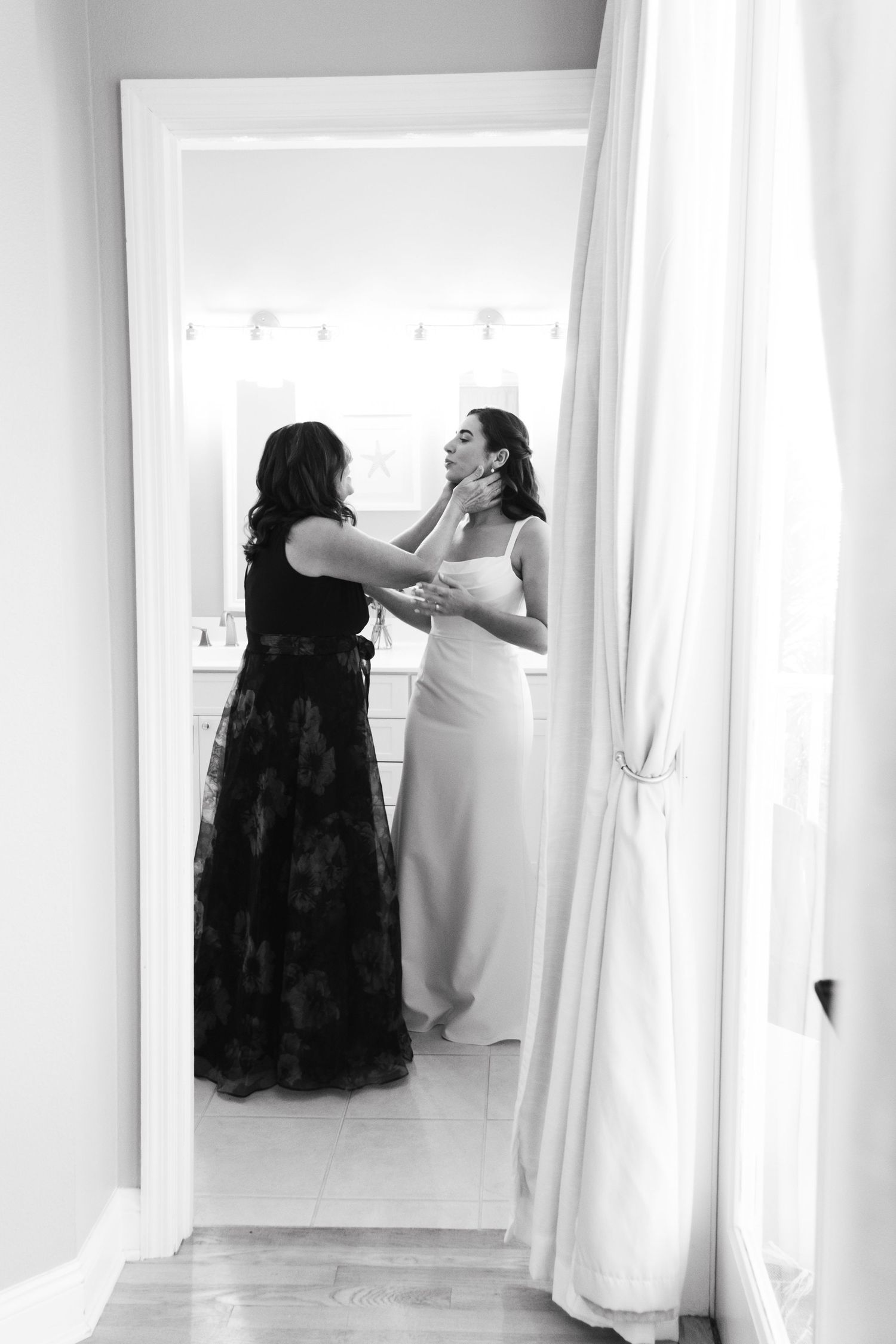 A series of black and white photos showing someone trying on a wedding dress in a bridal fitting room.