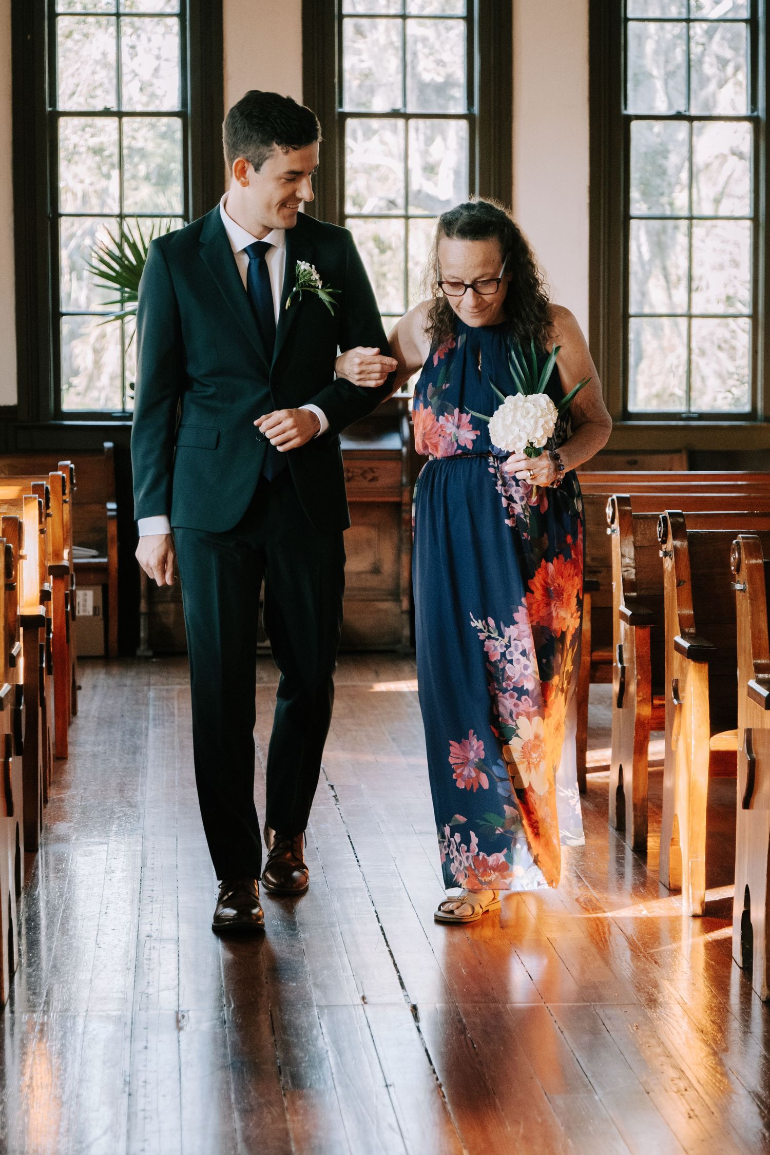 Elegant church interior with wooden pews and arched windows creates a romantic wedding setting.