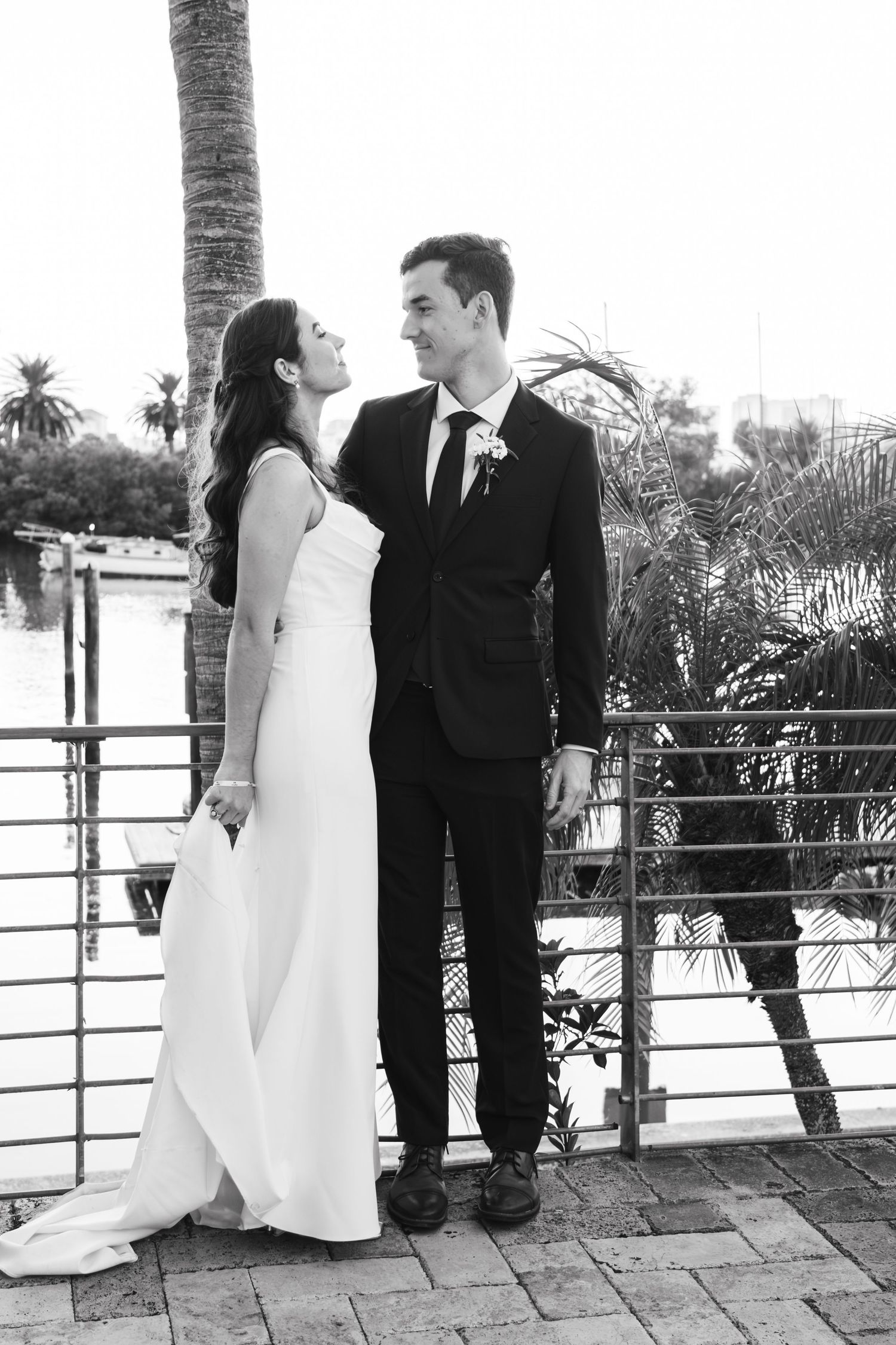 Black and white portrait of couple on tropical terrace with palm trees.