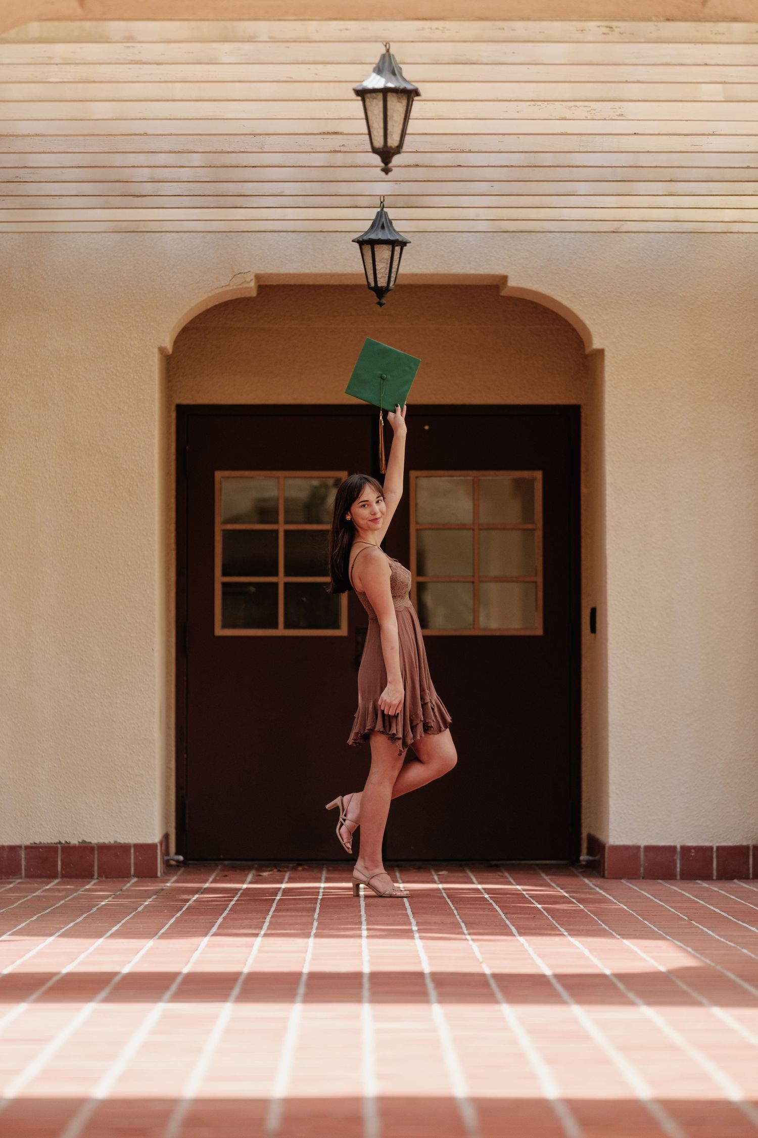 A dancer performs a graceful split leap sequence against a Spanish-style architectural backdrop with arches and lanterns.
