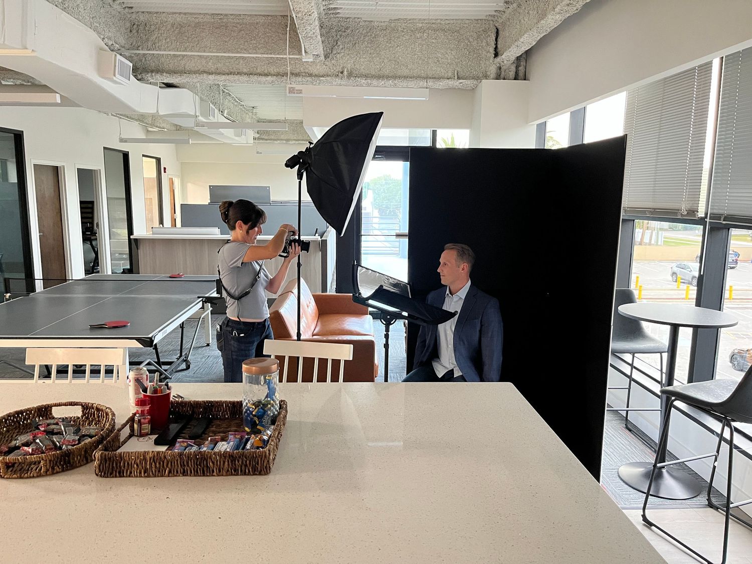 Professional photo shoot in progress with lighting equipment in an office setting.