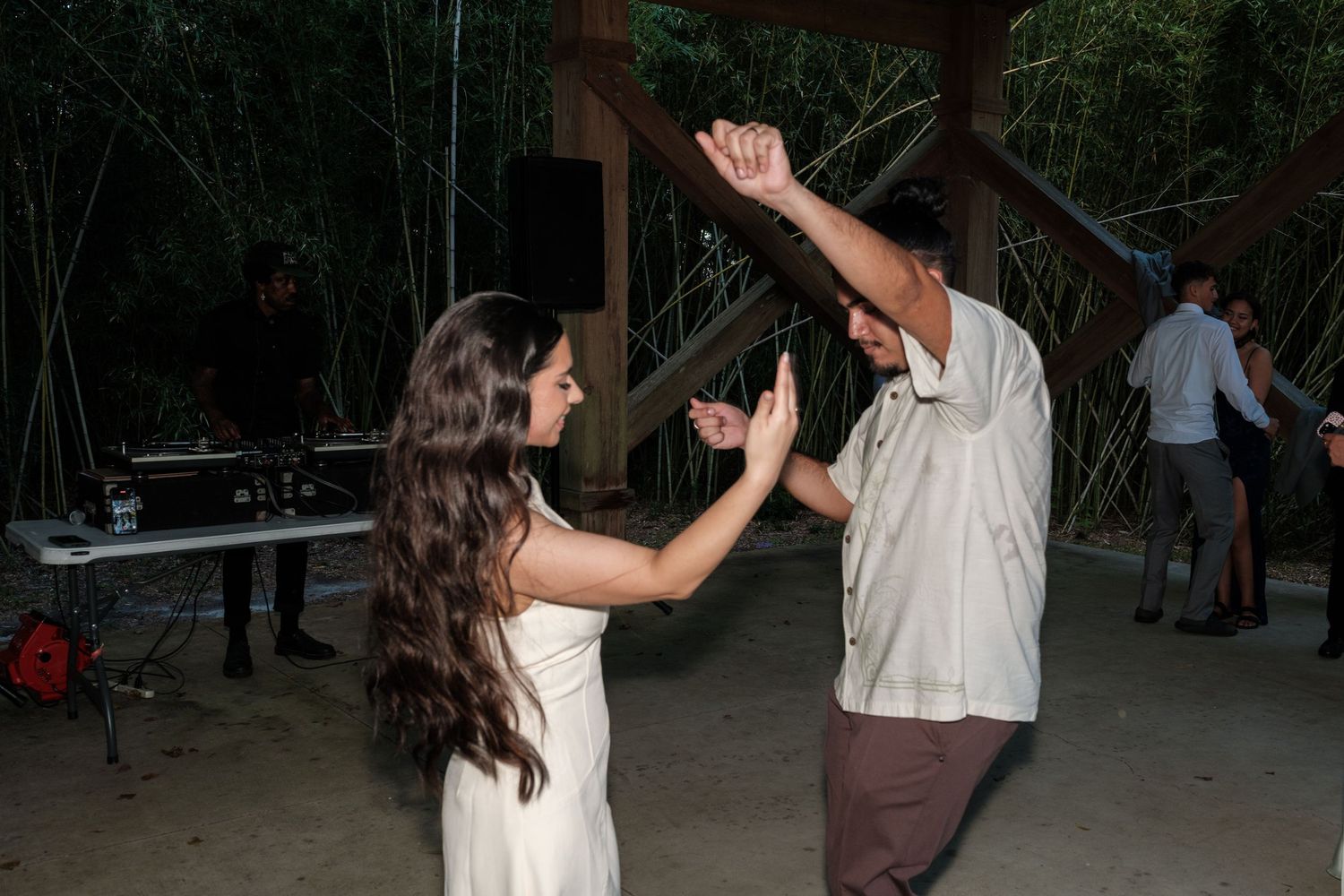 Wedding guests dancing and celebrating on an outdoor dance floor.