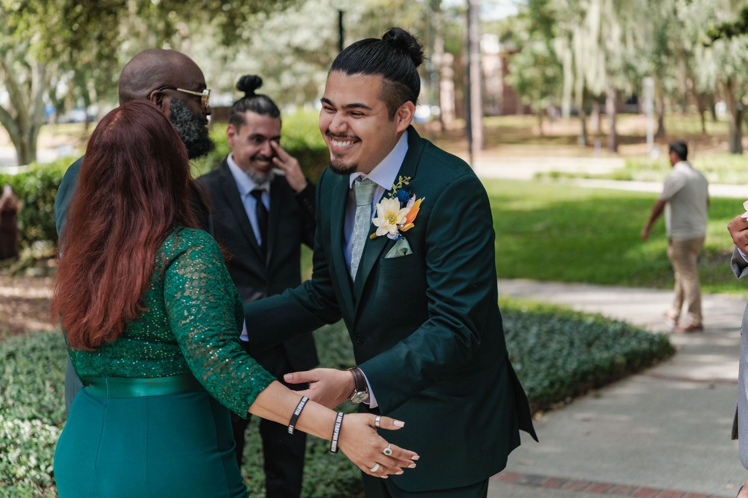 Joyful wedding moment captured outdoors with guests in formal attire.