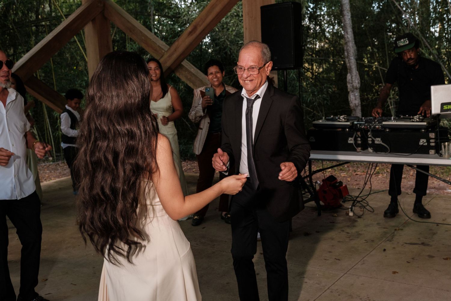 Wedding guests dancing and socializing during an outdoor evening reception.