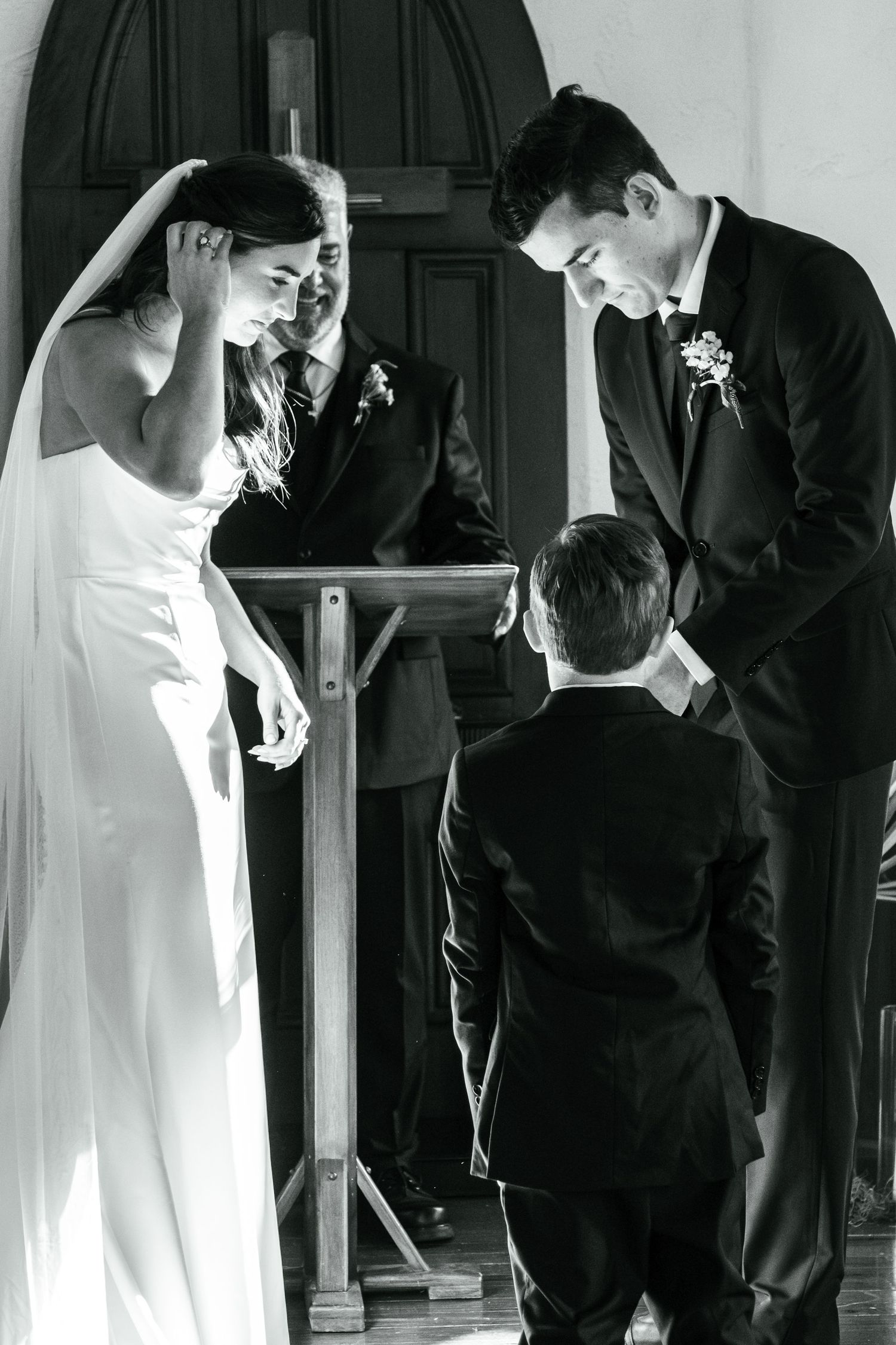 Black and white wedding photo series showing intimate moments between bride and groom in formal attire.