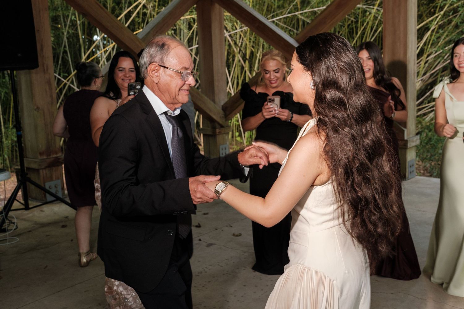 Couples dancing together during an outdoor wedding reception celebration.