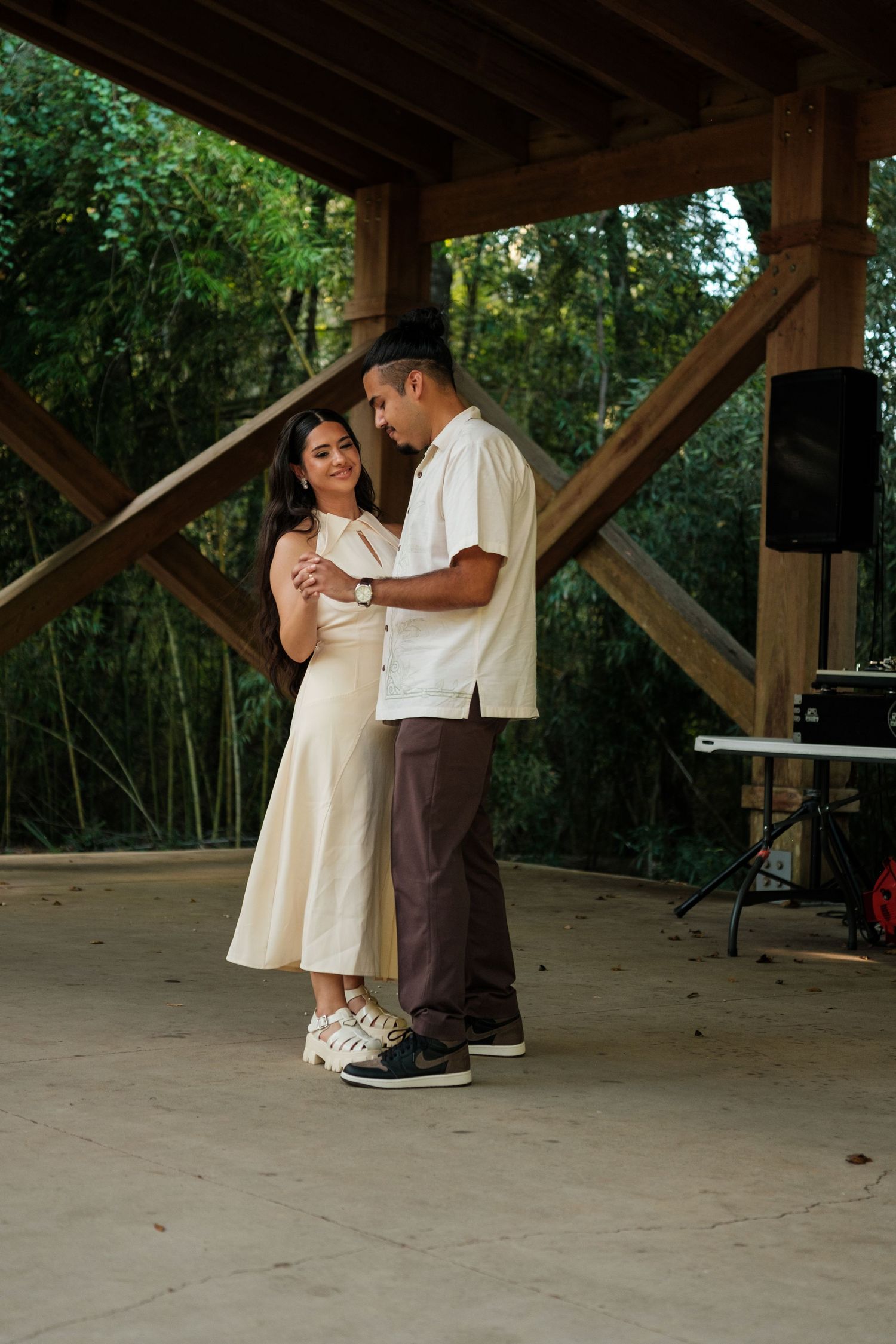 Romantic dance moment under a covered outdoor pavilion.