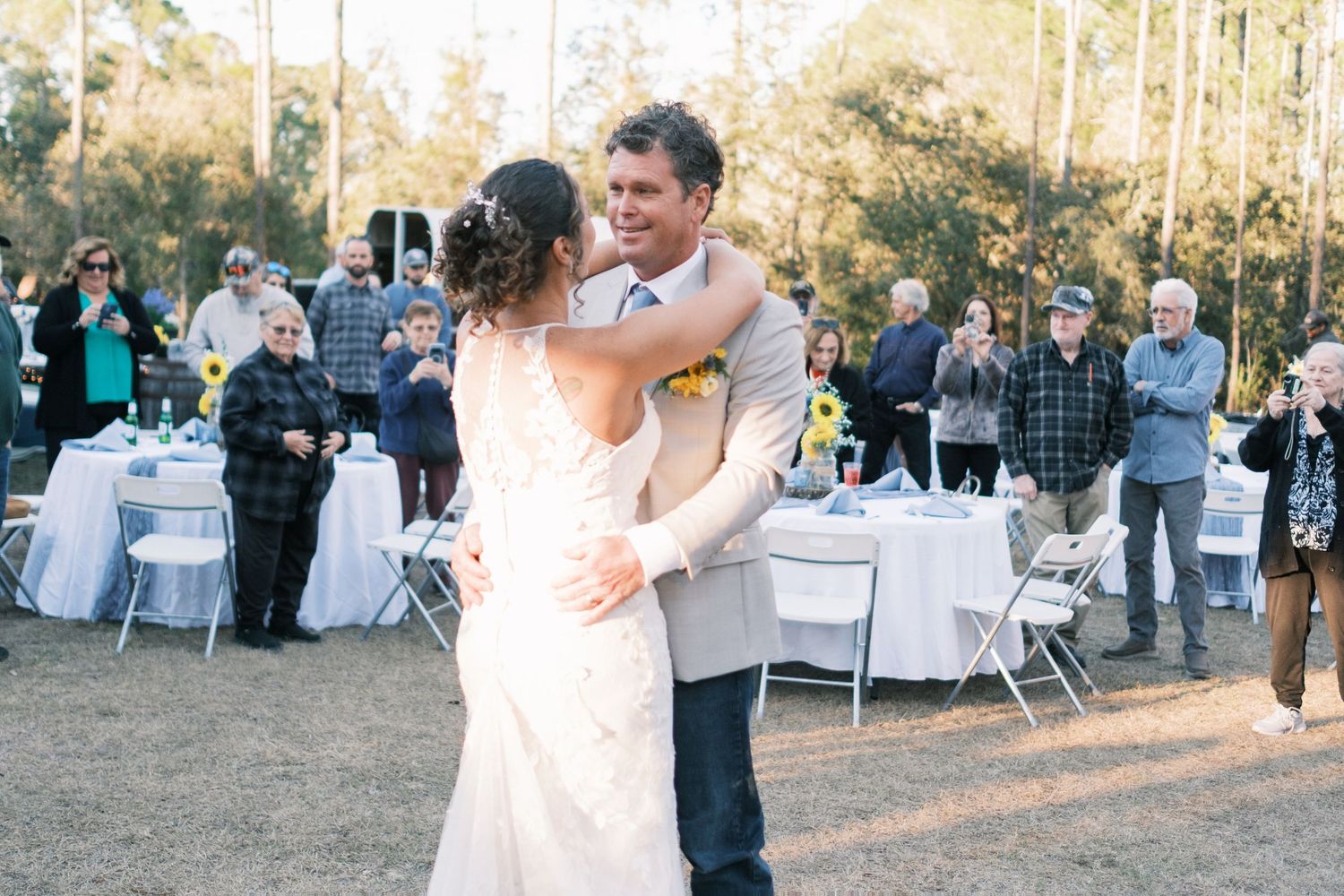 Bride and groom share their first dance at an outdoor woodland wedding reception.
