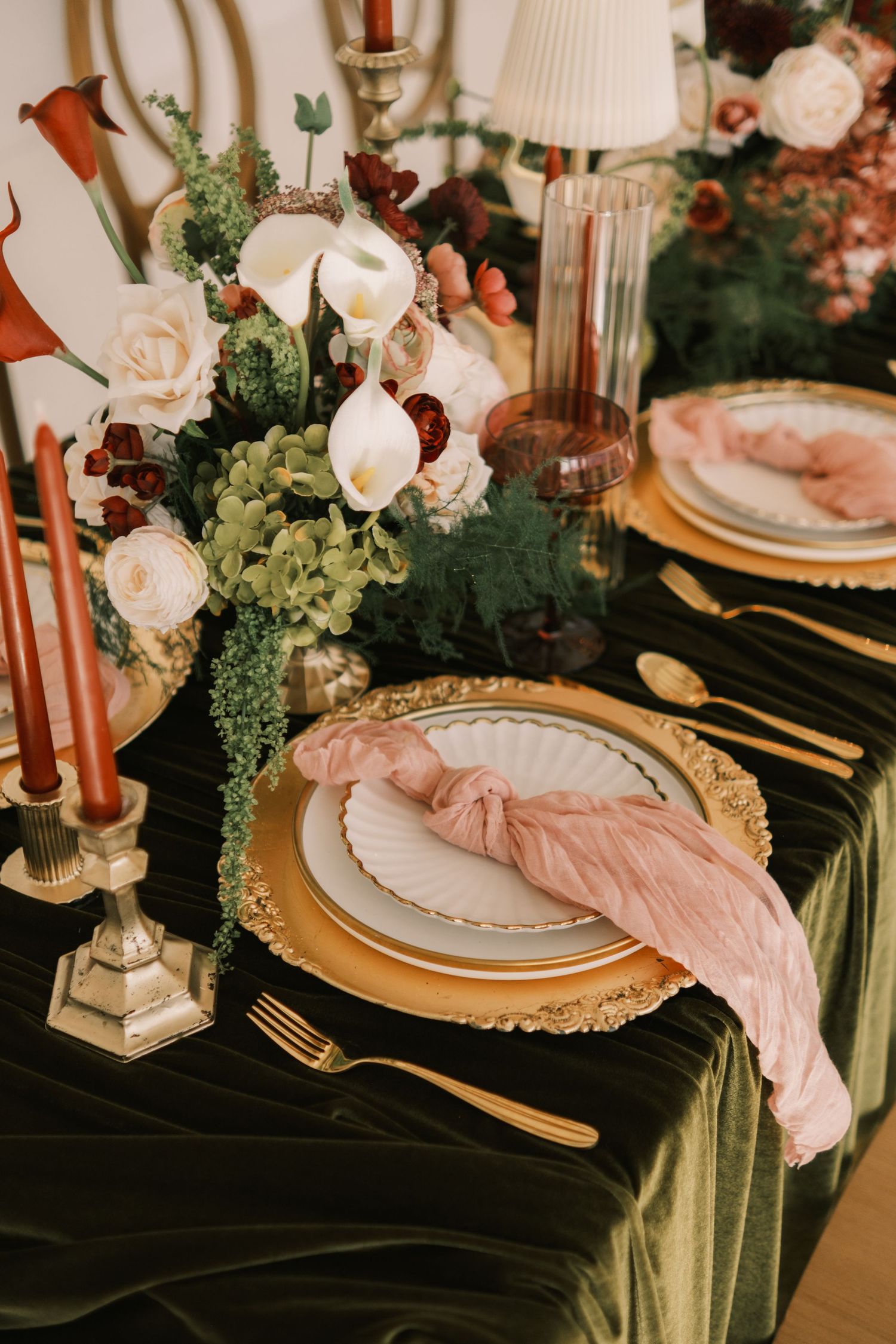Luxurious table setting with gold chargers, velvet linens, and blush accents.