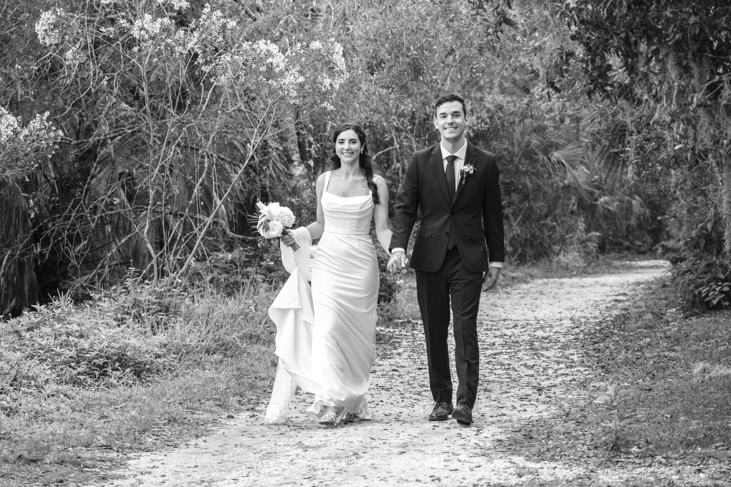 A sequence of black and white wedding photos showing a couple walking together on a garden path.