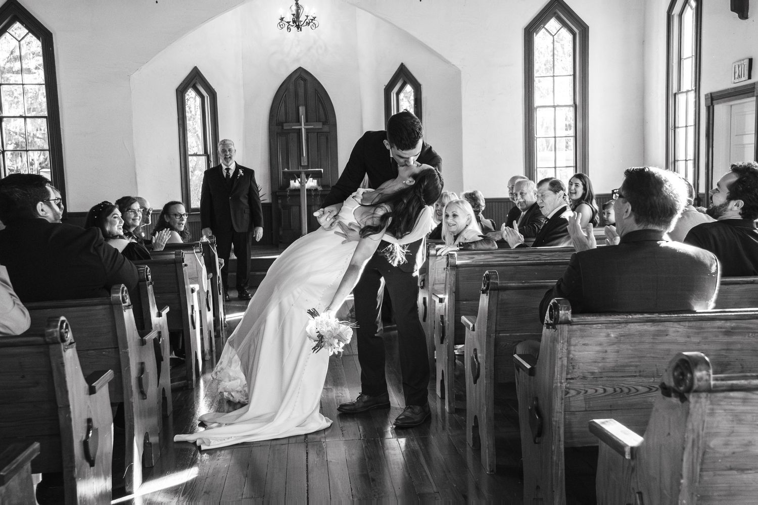 Black and white photo of wedding ceremony in traditional church with gothic architecture.