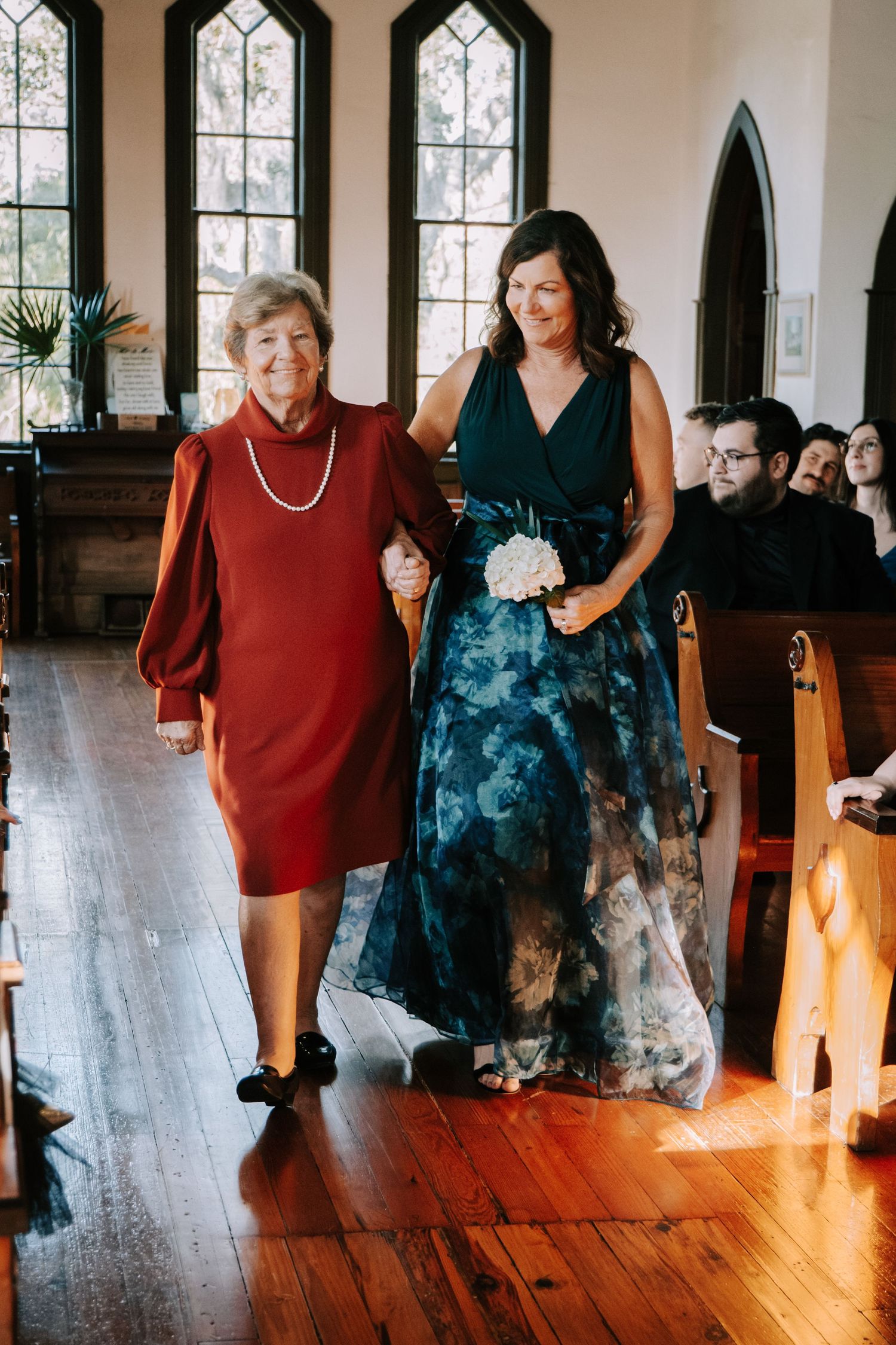 Gothic-style interior with arched windows and wooden floors during a wedding preparation.
