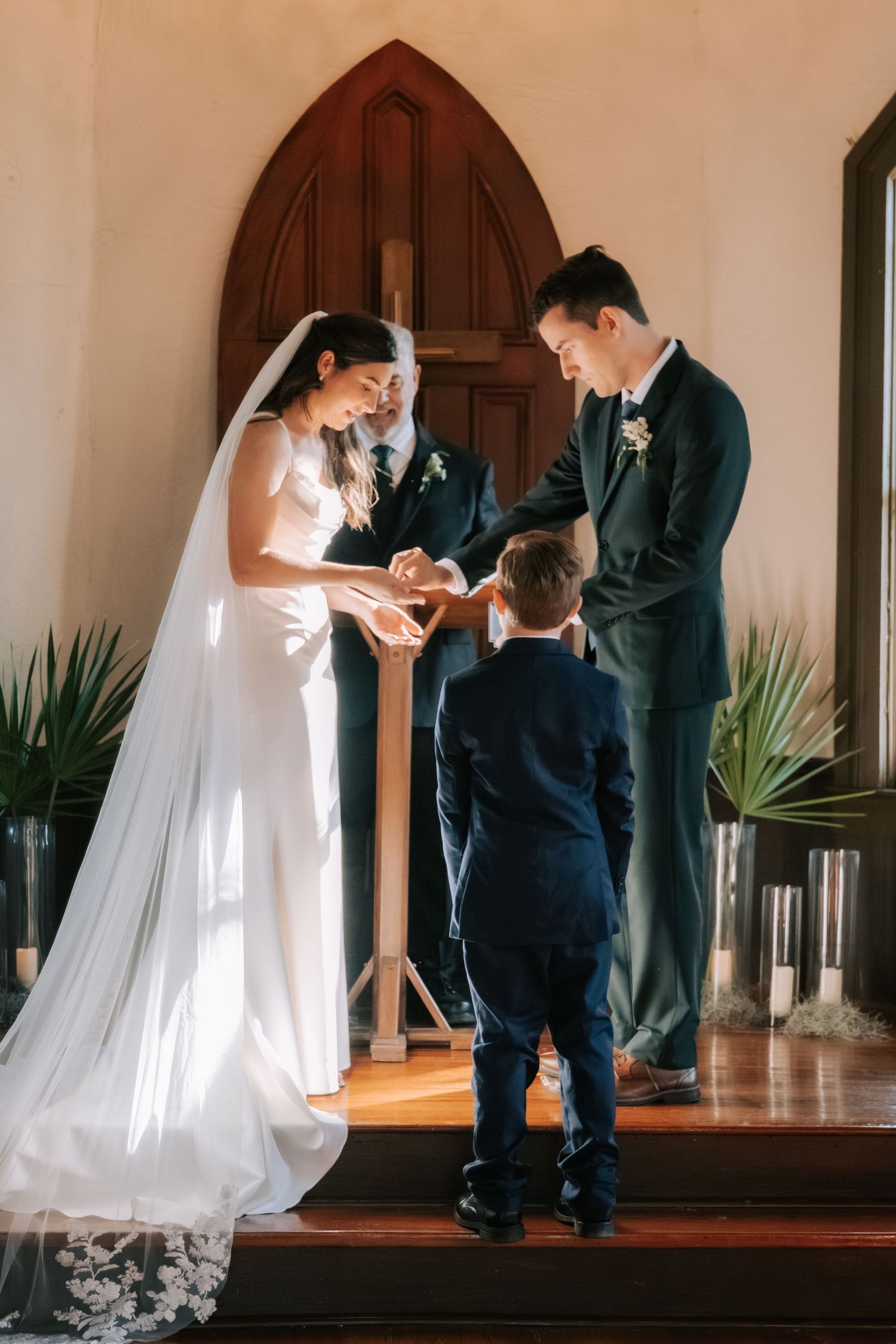 Sweet ceremony moment with young ring bearer in church setting.