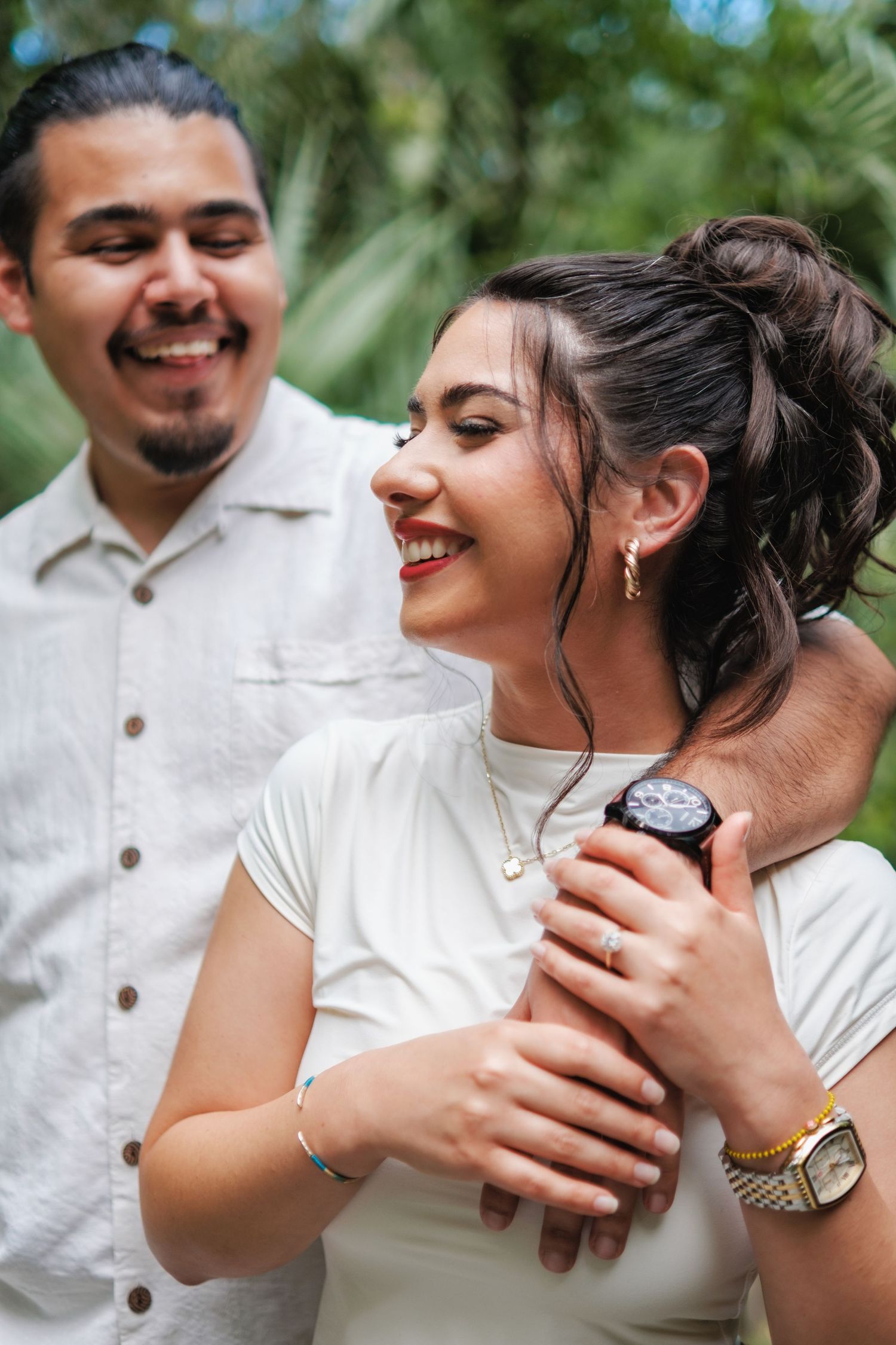 Candid moment of laughter shared between couple in casual attire outdoors.