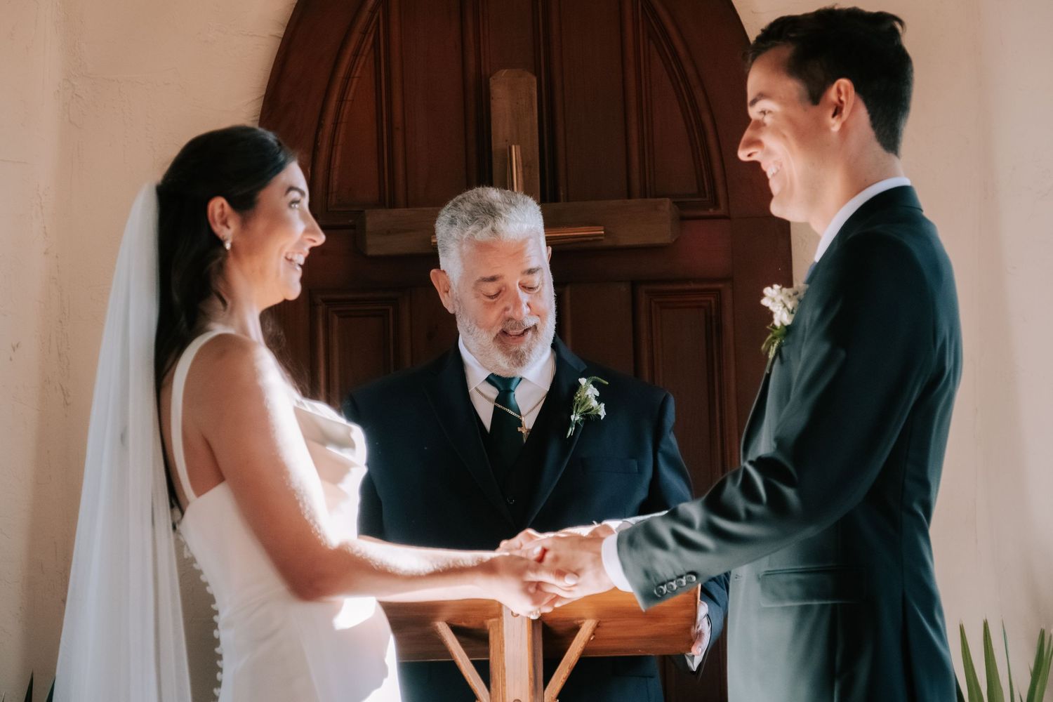 A wedding ceremony takes place indoors as a couple exchanges vows before an officiant.