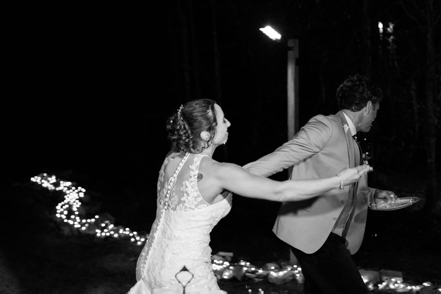 Black and white photo of bride and groom sharing first dance at outdoor wedding.
