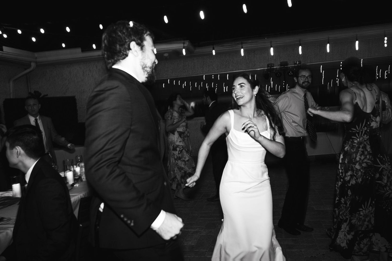Wedding reception dance floor with string lights creating a romantic atmosphere.