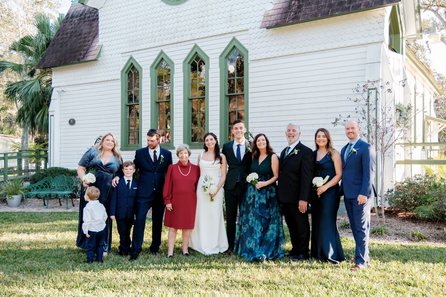 Group photos of wedding guests and family members outside a traditional white church building.