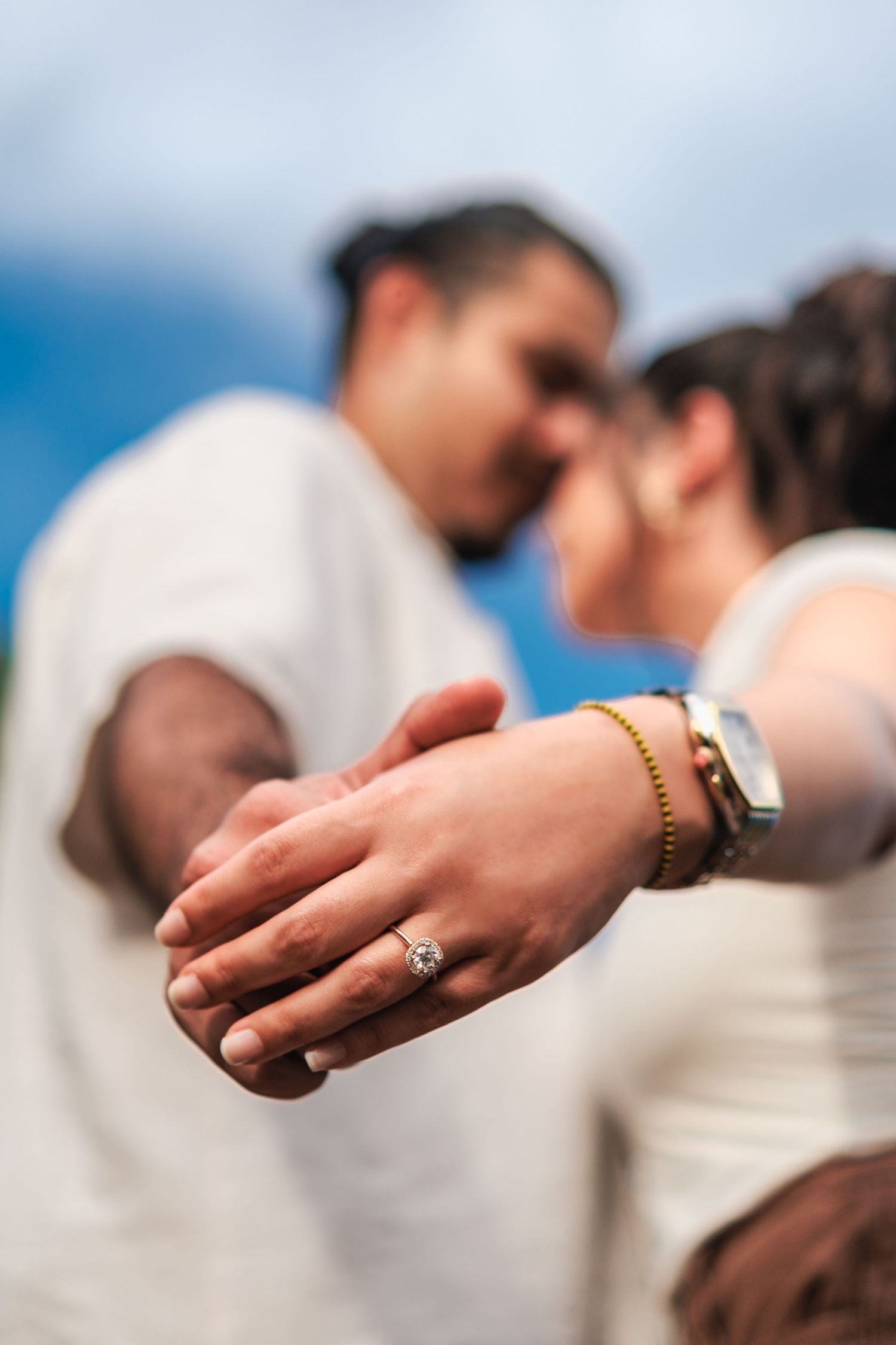 Close-up shots of hands displaying an engagement ring against a blurred background.