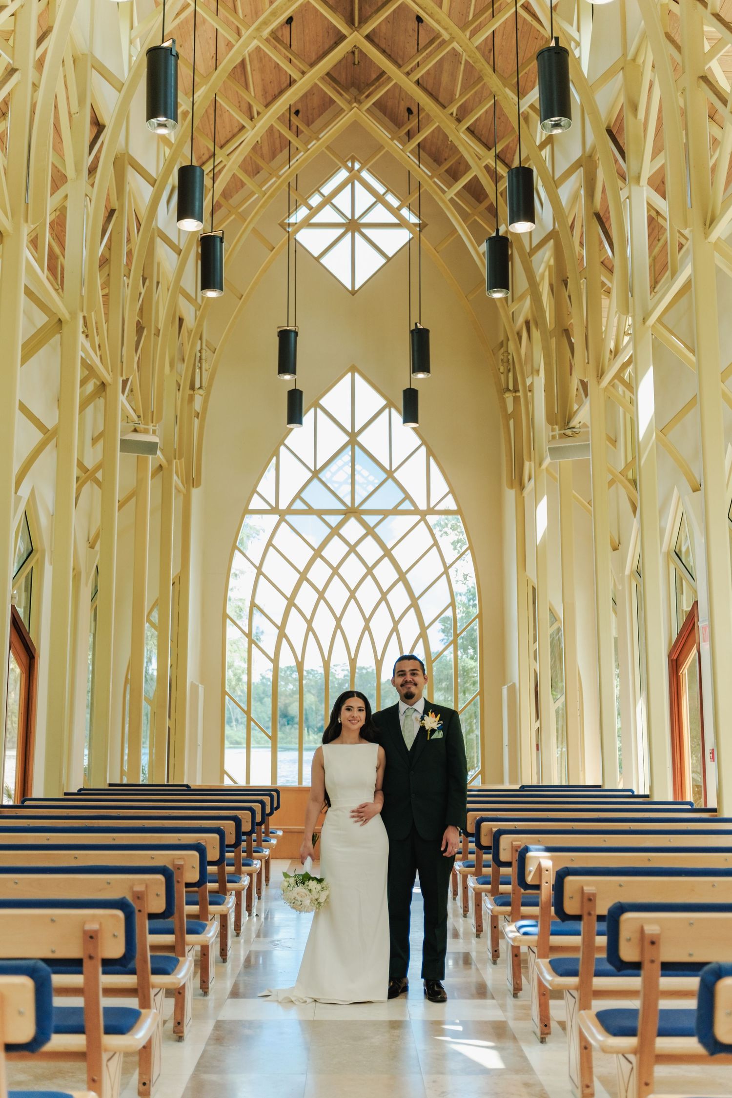 Elegant chapel interior with wooden beams and geometric windows during a wedding ceremony.