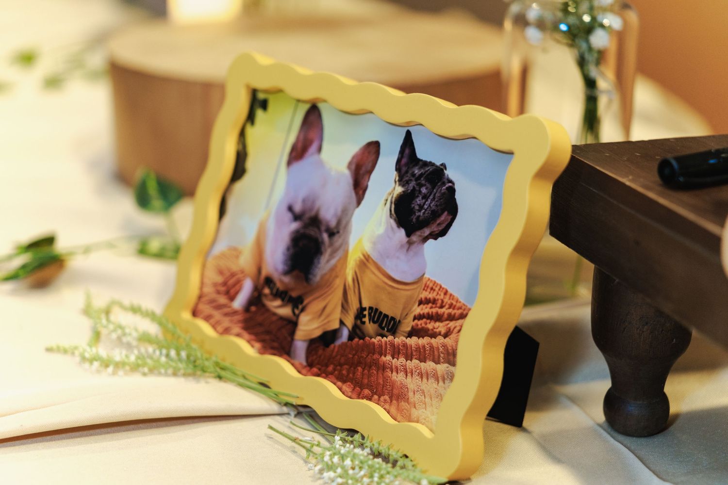 Wedding reception table decorated with framed photos and floral accents.
