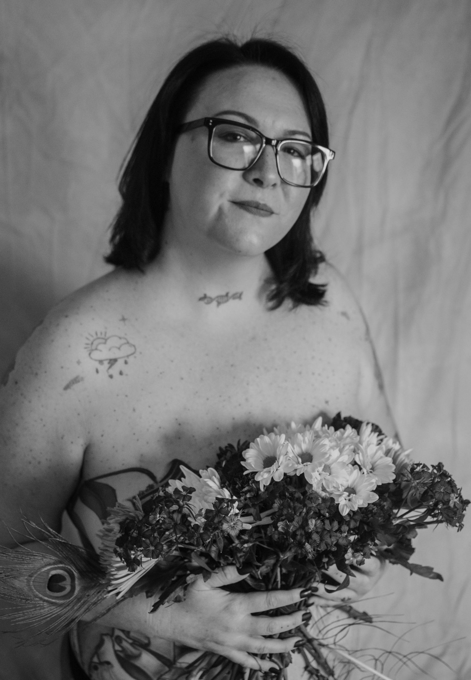 A monochromatic artistic series showing a person with glasses holding a bouquet of flowers in a dreamy, intimate setting.