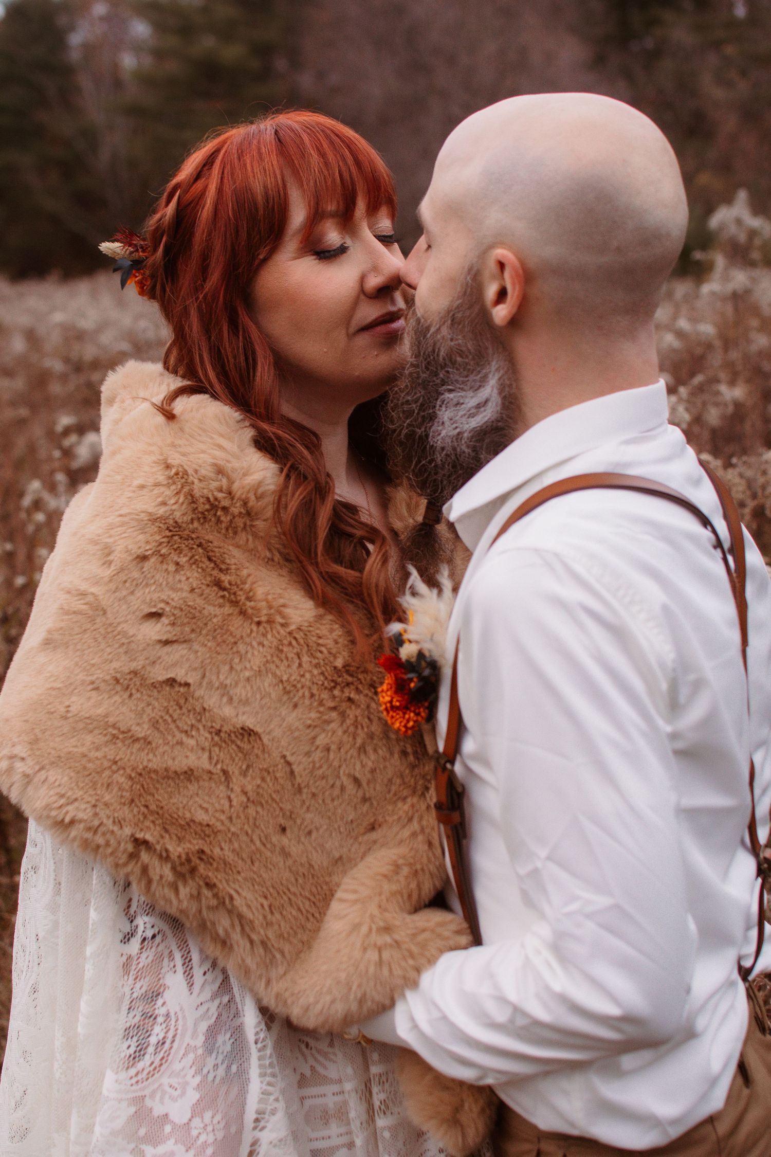 A romantic autumn wedding scene with a couple embracing, featuring a fur shawl and rustic attire.