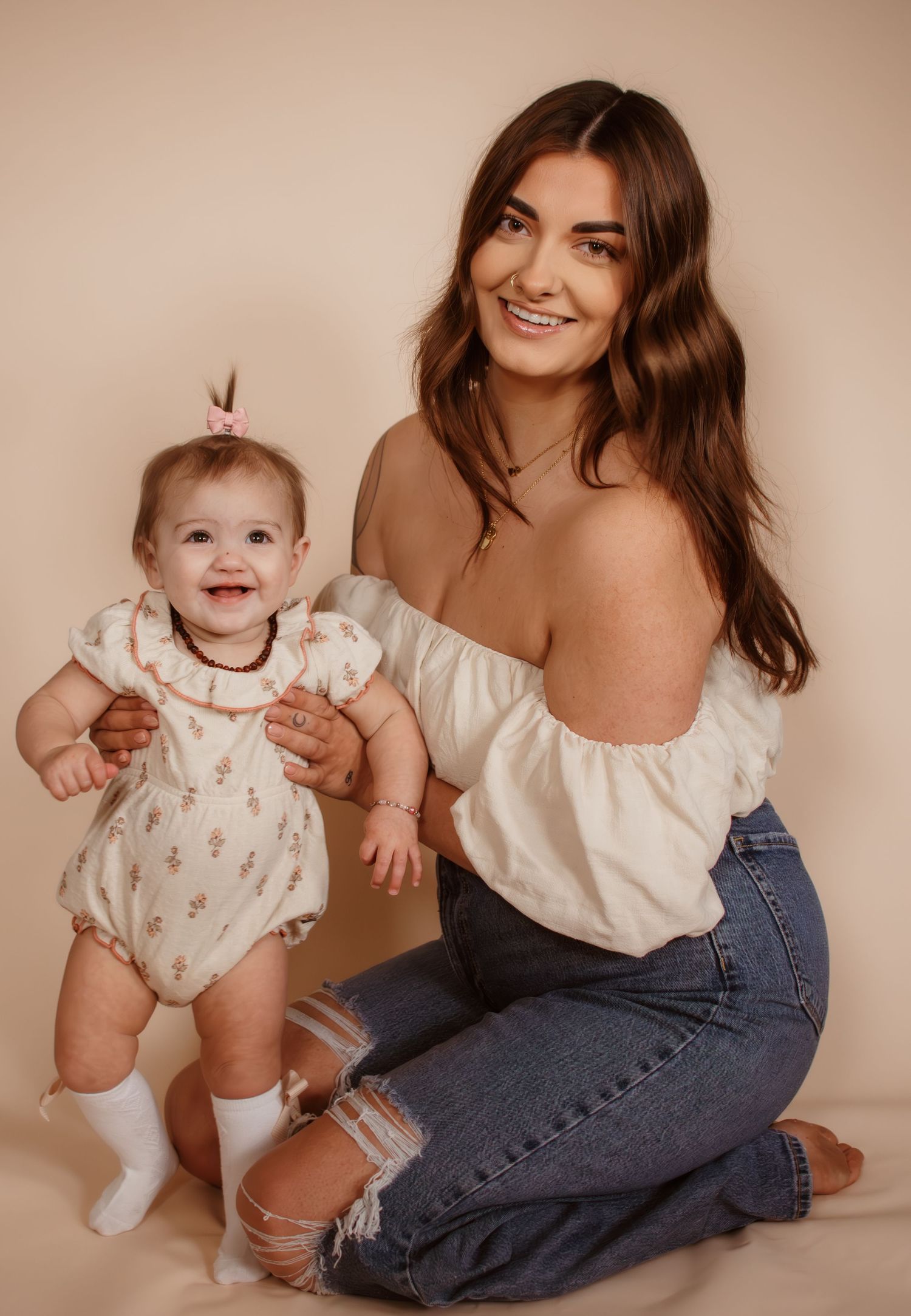 A series of heartwarming milestone portraits capturing candid moments between parent and child in warm neutral tones.