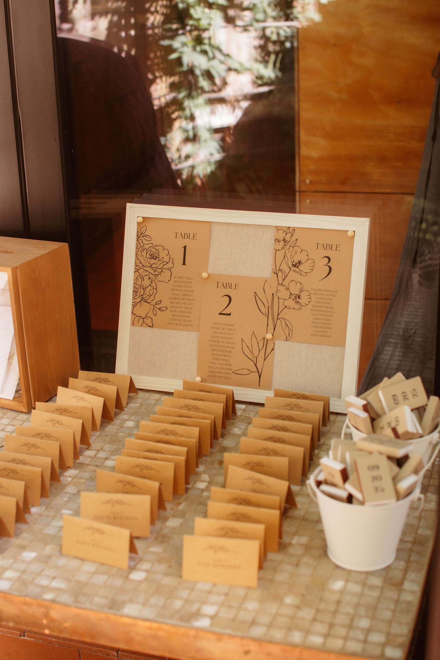Wooden table number holders arranged in rows with rustic decor elements for wedding reception seating.