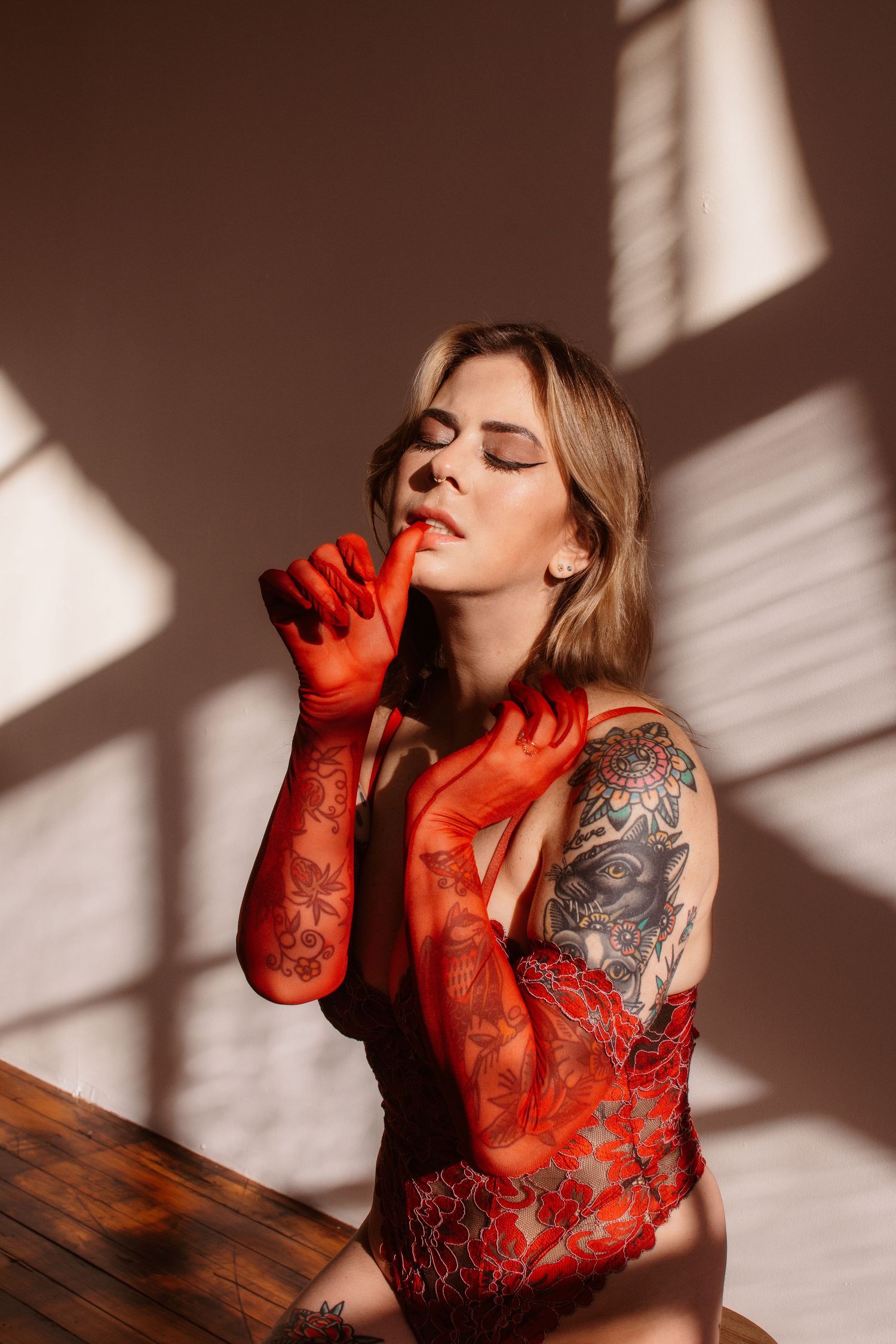 Sensual portrait series featuring red lace and dramatic shadow patterns from window light.