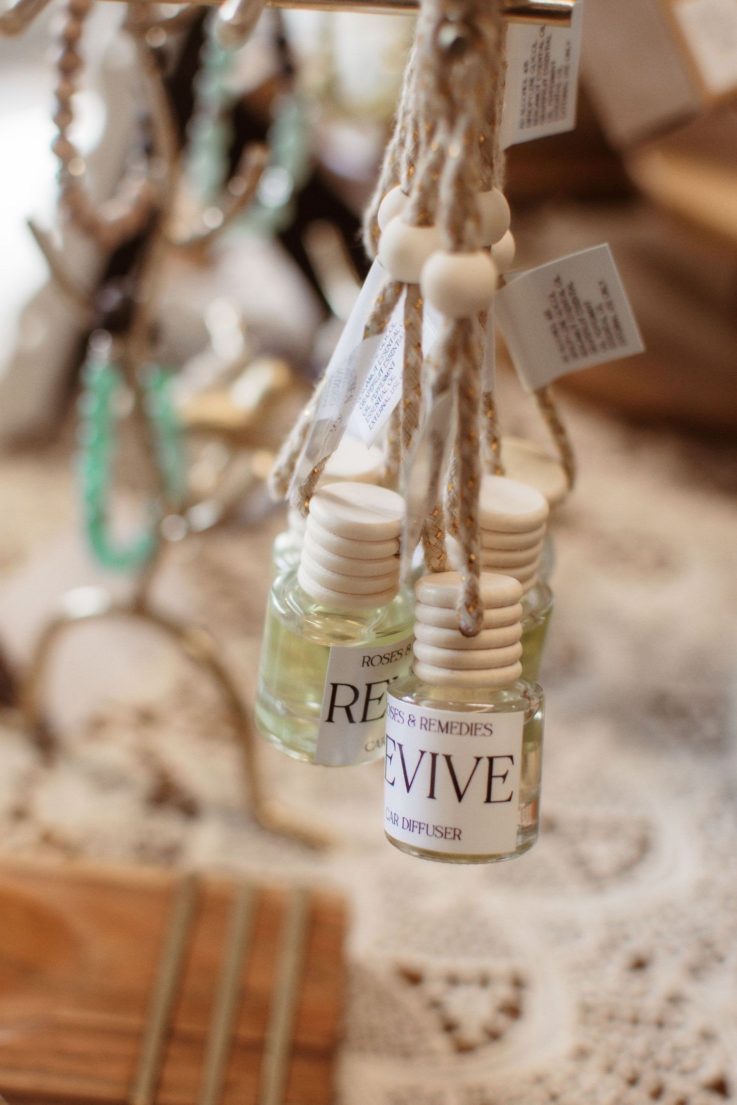 A row of vintage glass bottles with 'revive' labels displayed on lace doily against a rustic wooden background.