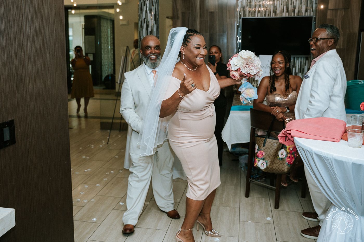 Wedding guests dancing and celebrating at an indoor reception venue with elegant decor.