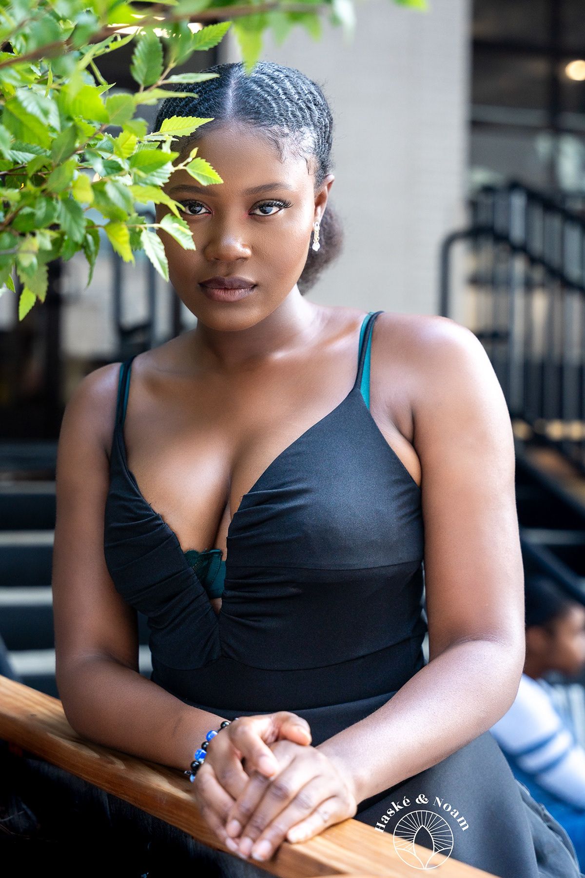 Outdoor portrait featuring black swimsuit and braided hairstyle in natural setting.
