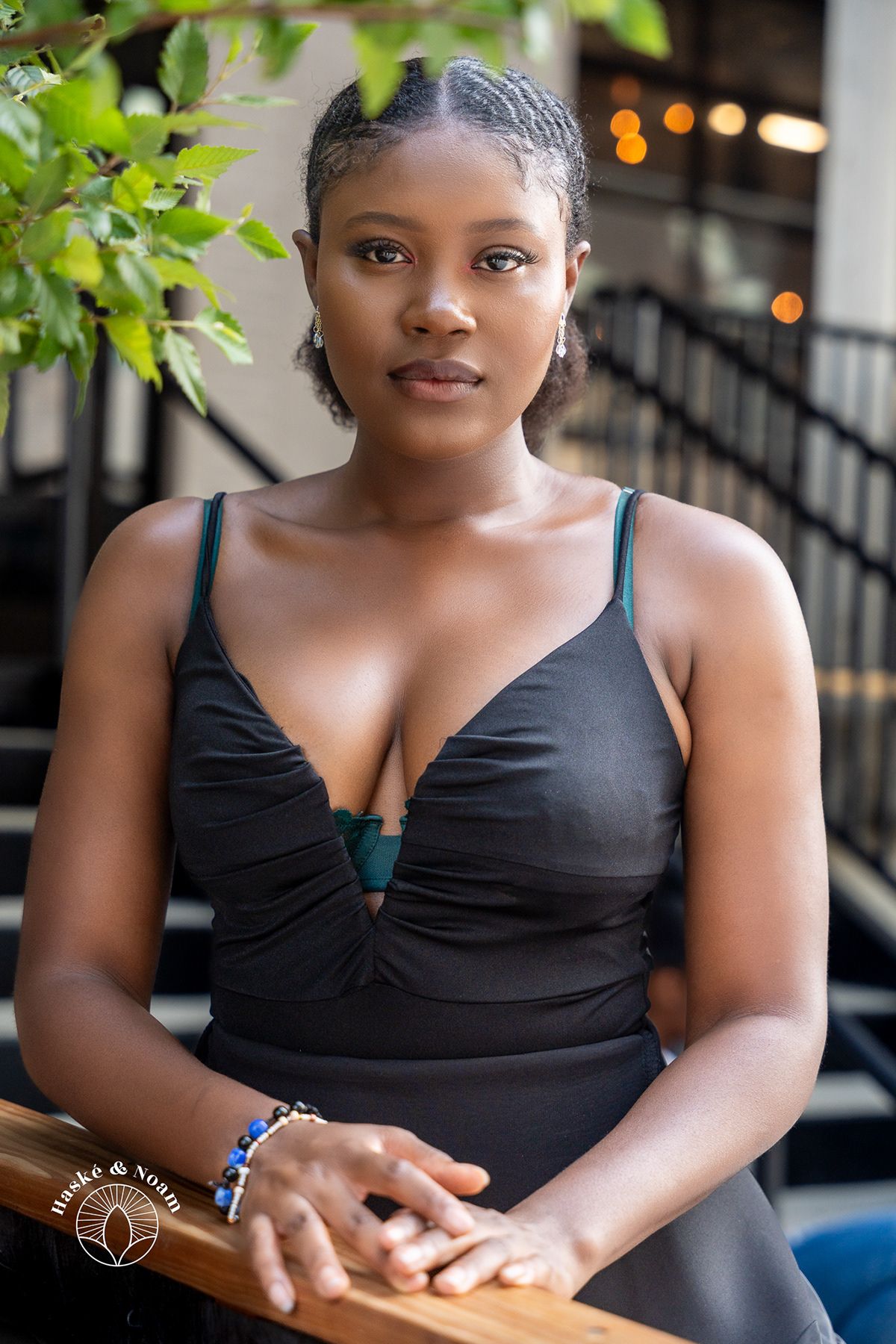 Portrait of person in black formal dress sitting at outdoor venue.