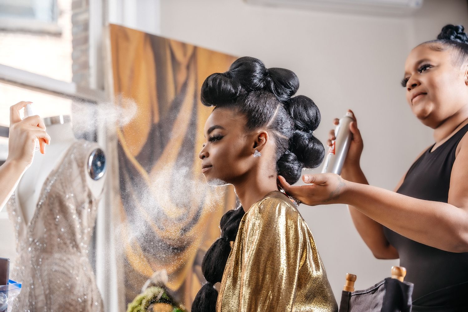 A glamorous styling session featuring a gold robe and professional hair preparation.
