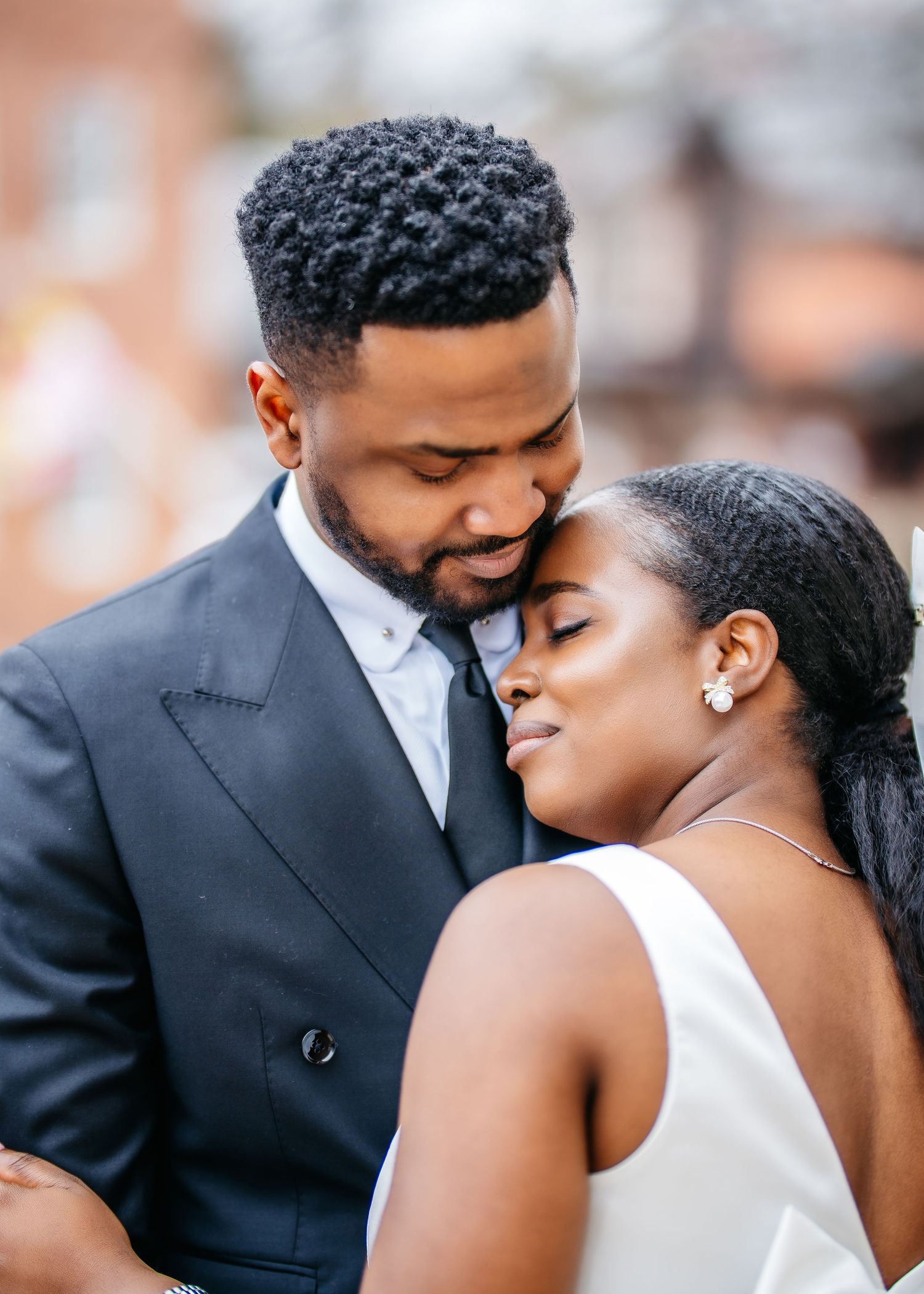 A romantic wedding couple shares an intimate moment together while dressed in elegant attire.
