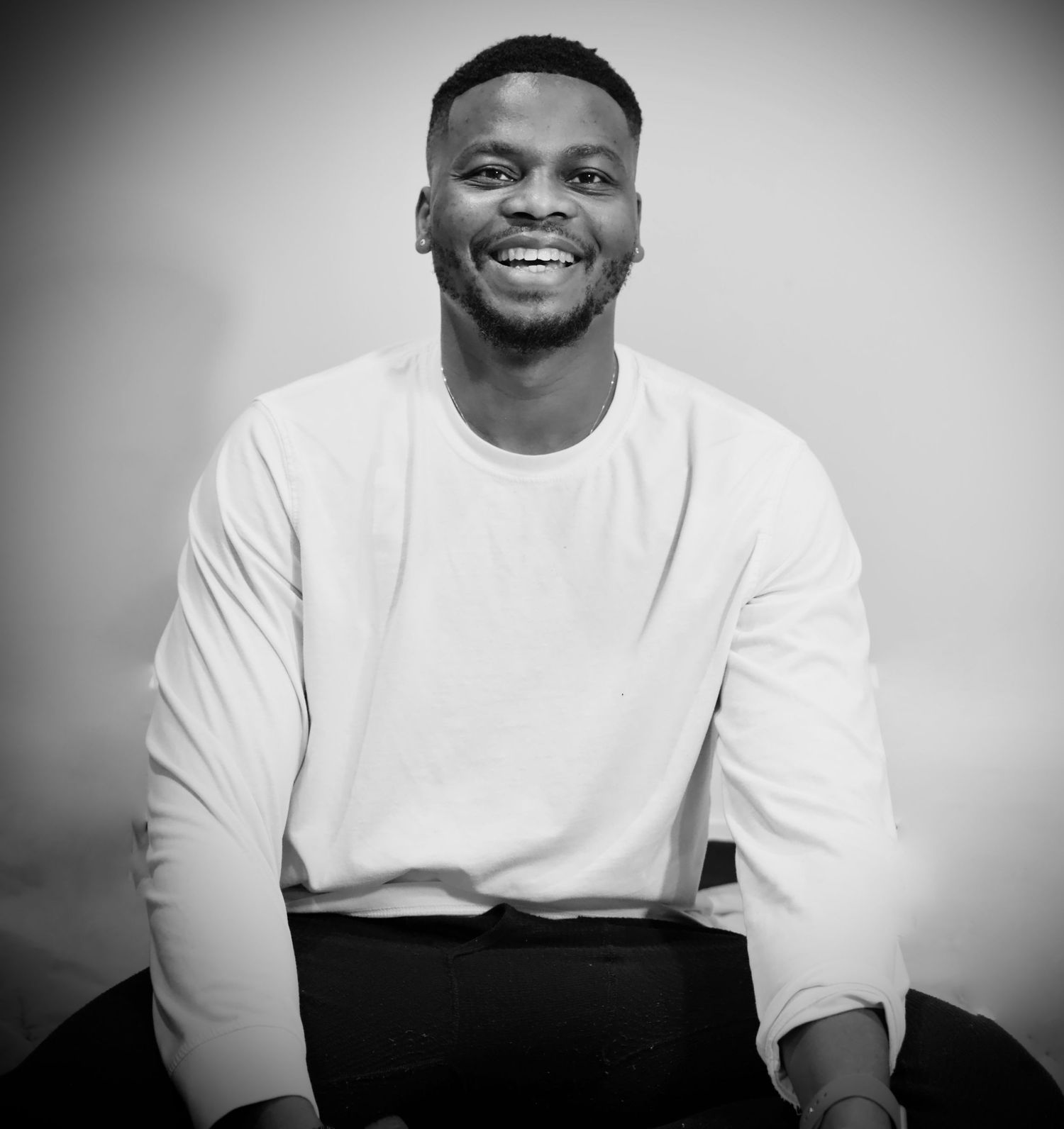 Portrait of someone wearing a white sweater in a professional black and white photo shoot.