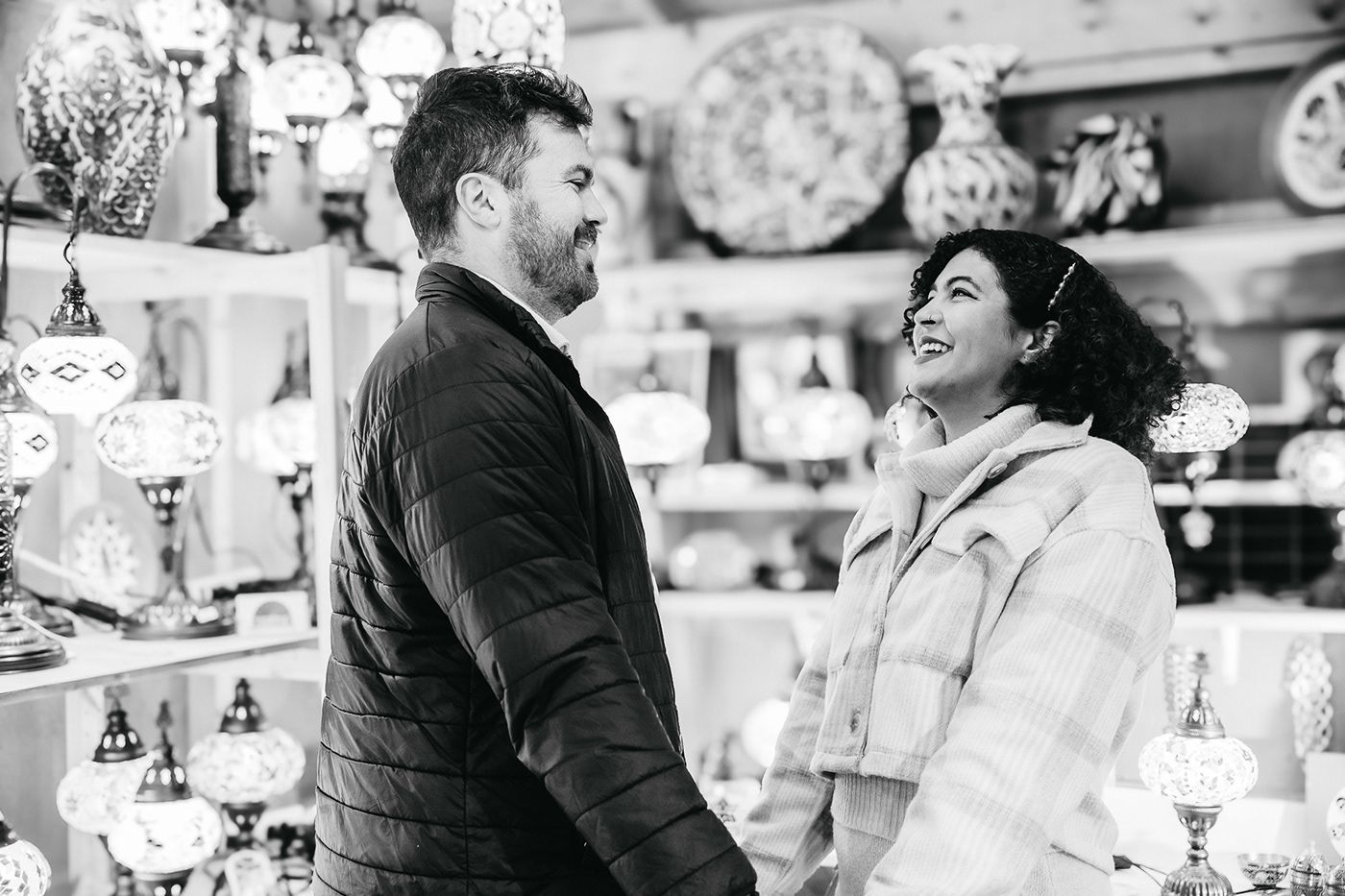 A couple shares a joyful moment while shopping among decorative holiday displays.