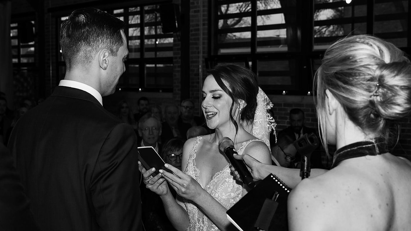 Black and white photo of guests mingling at an evening wedding reception.