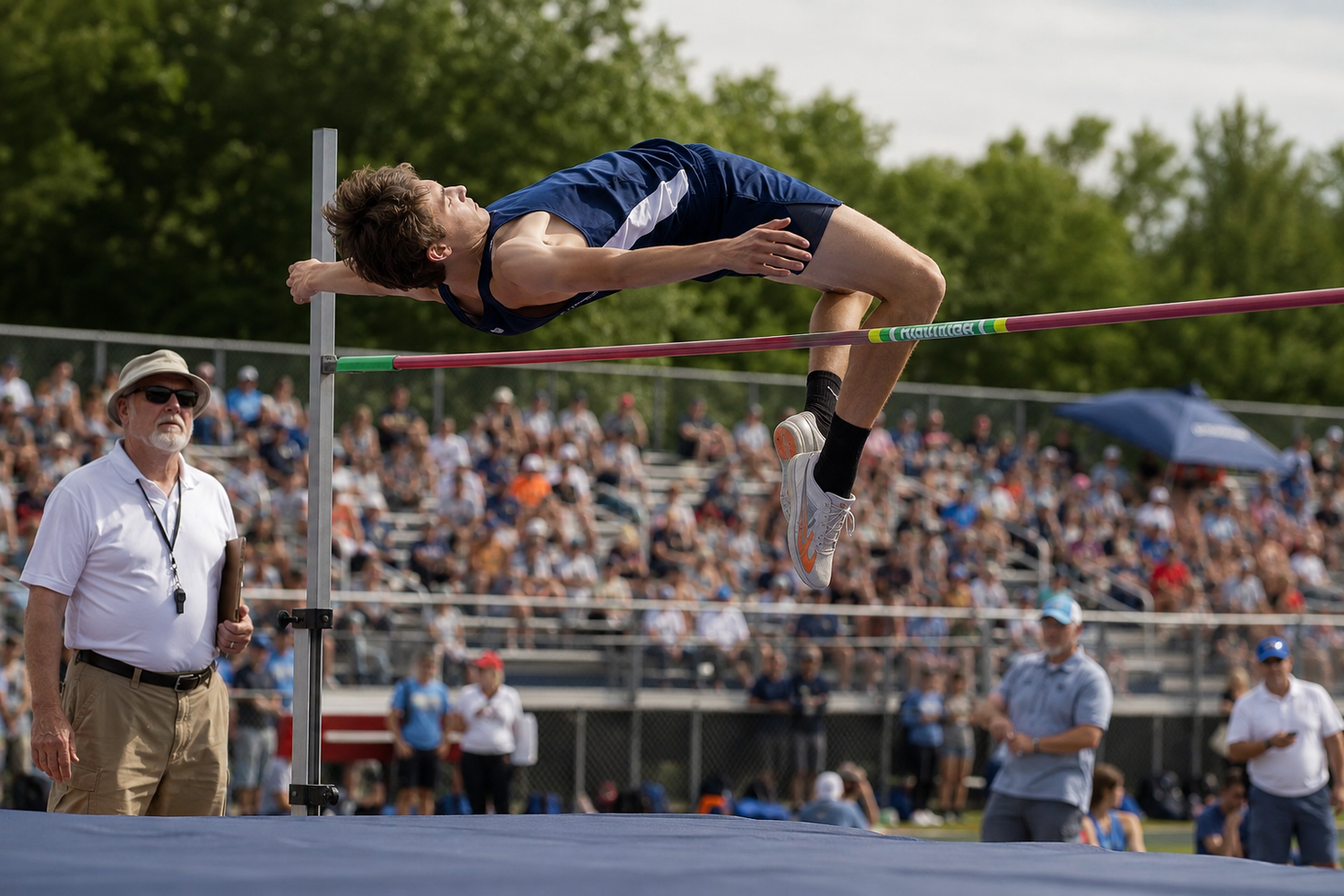 Athlete performs a high jump at a packed outdoor track and field competition on a sunny day.