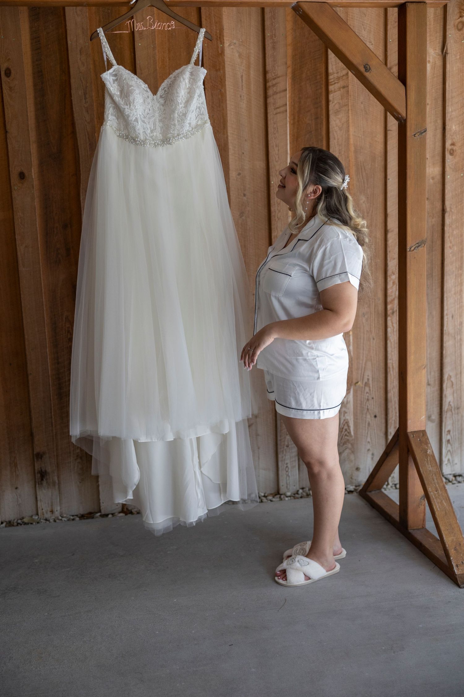 A sequence of four wedding dress preparation photos showing white gowns hanging against a rustic wooden wall.